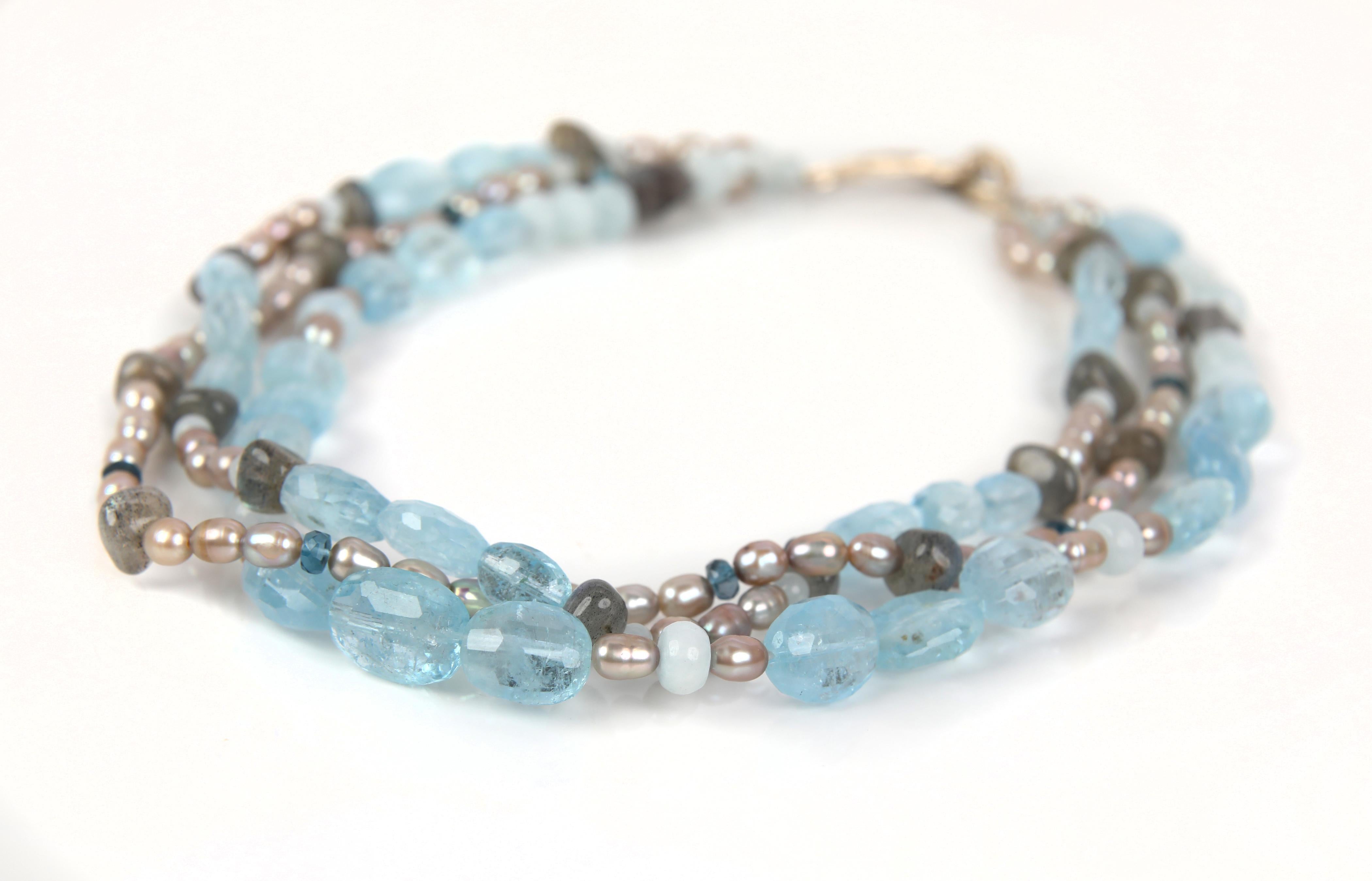 A necklace of pearl, aquamarine, topaz, labradorite, and white gold invokes visions of that magical place at the horizon where soothing blue seas meet blue skies.  The confluence offers an infinite pallet of blues and frothy cream.  

