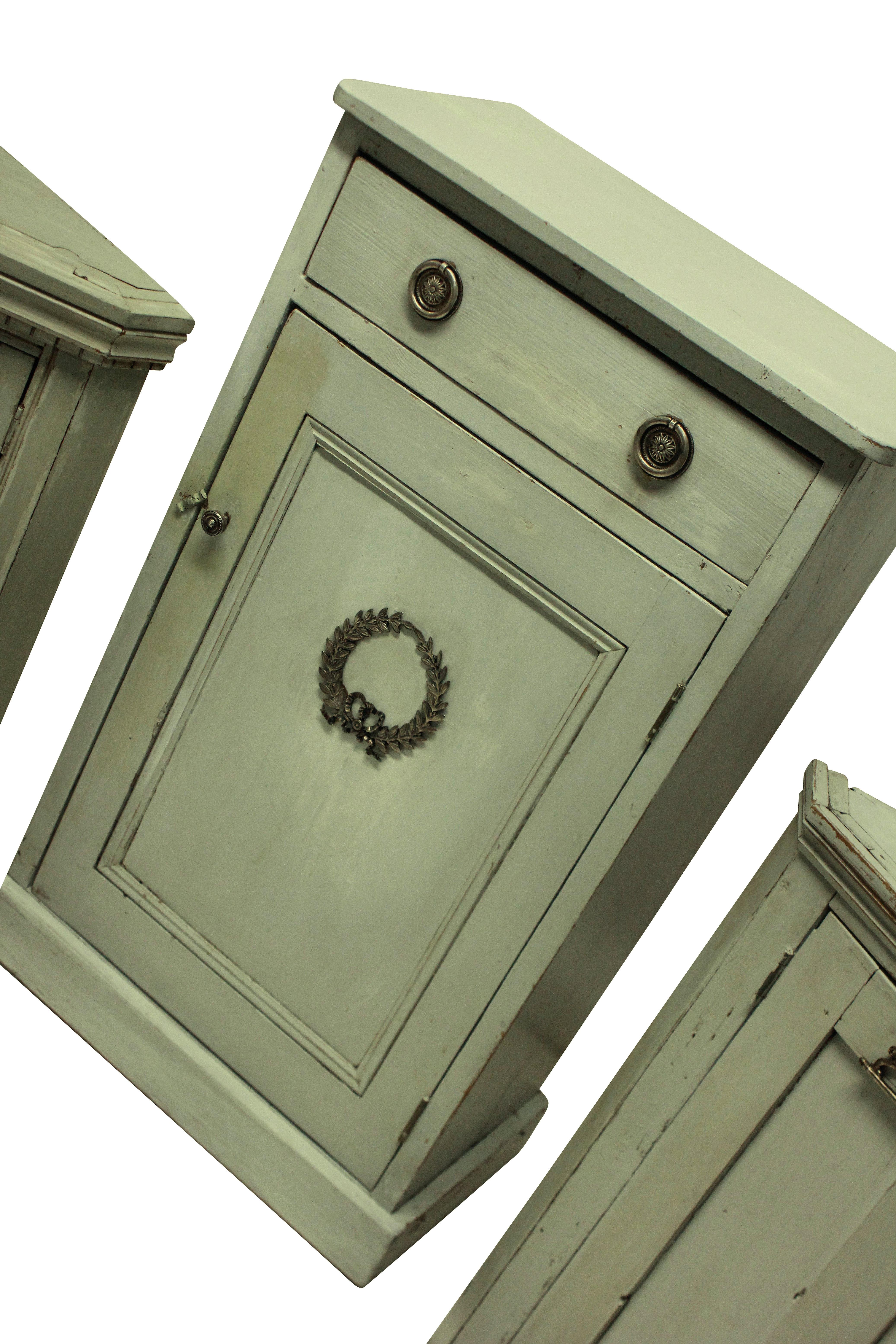 A set of three painted Swedish cupboards, comprising a larger cupboard with drawer and two floor standing corner cupboards, each with a shelf. The exteriors decorated with silver plated bronze mounts.

Measures: Large cupboard 106 high x 38 deep x