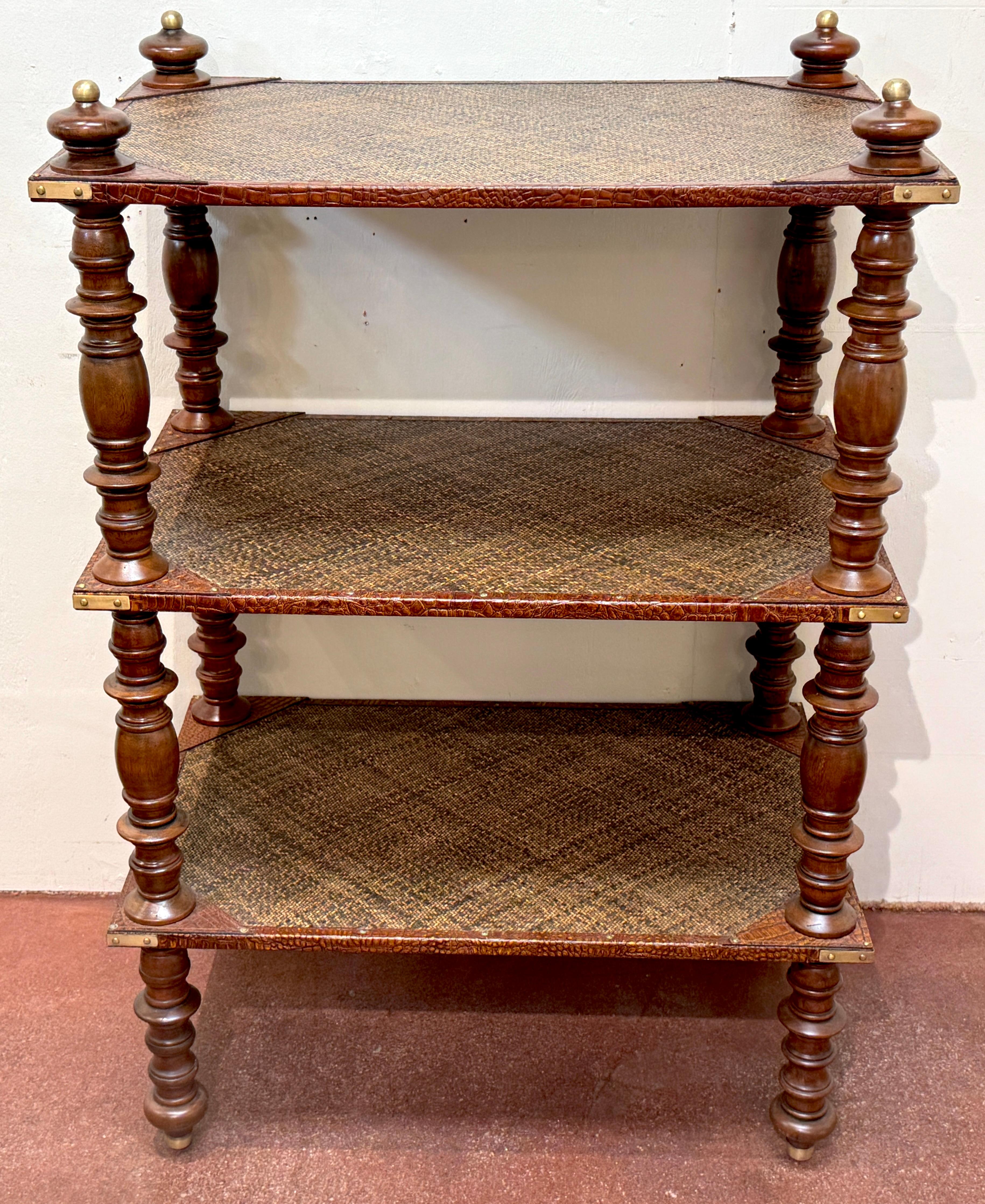 Three-Tier Anglo-Indian Leather, Brass & Rattan Étagère/Shelf

A refined and beautifully detailed Anglo-Indian three-tier étagère featuring a rich combination of materials and colonial-era craftsmanship. The structure is built around turned hardwood