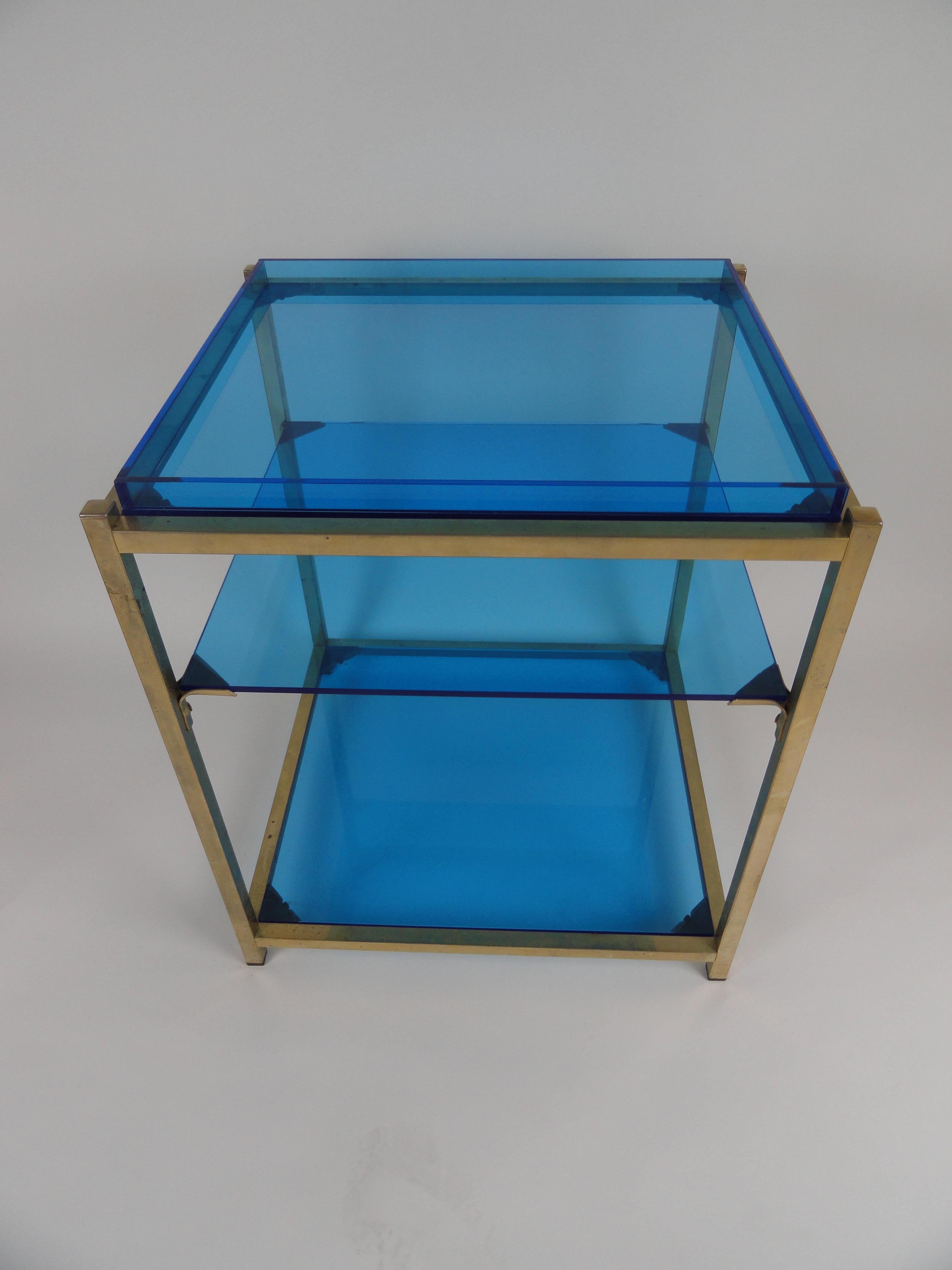 Three-tier brass table with custom blue acrylic tray top and shelves.