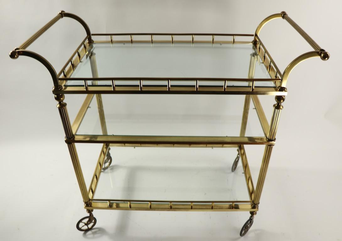 Glamorous and chic brass and glass serving cart attributed to Maison Jansen. Hard to find the three tier version, original, clean and ready to use.
Specific dimensions as follows:
Total H including handle 36 x H to top shelf 31 x second shelf 22 x