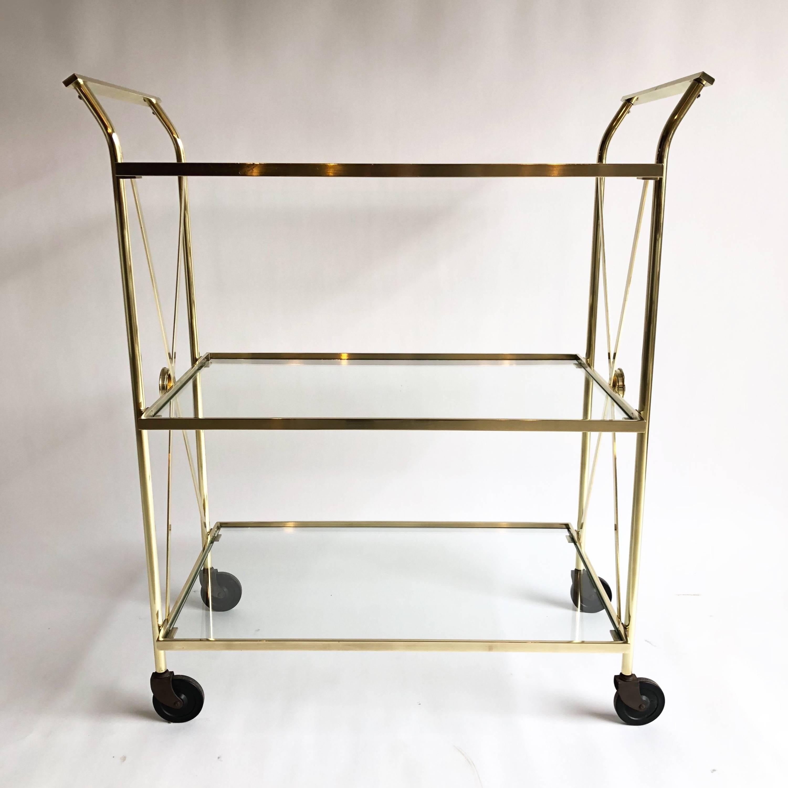 Three-tier brass bar cart with glass shelves.