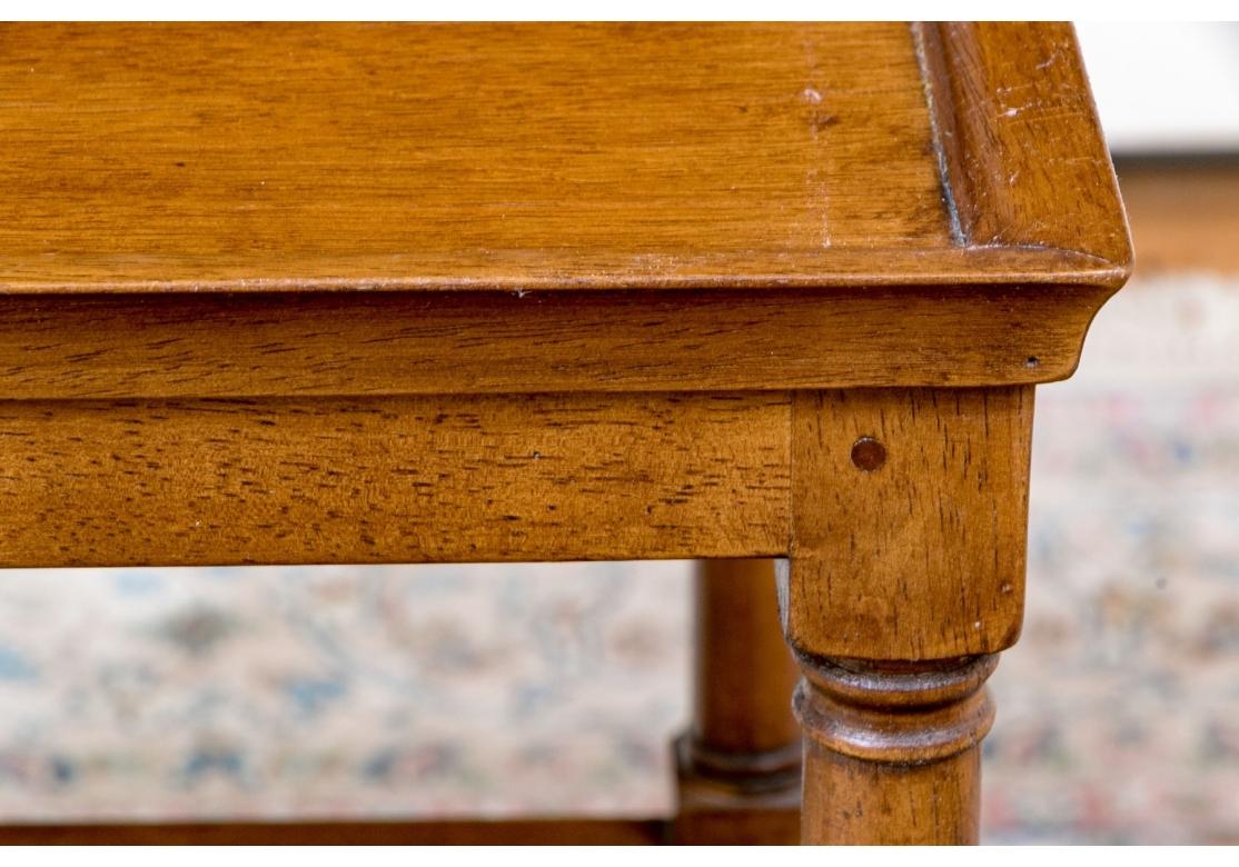 Table d'appoint vintage de style provincial français ou Coloni britannique à trois niveaux caractérisée par un cadre en bois, des pieds tournés avec des pieds en laiton et des étagères en cannage (rotin tressé).

Dimensions : 15 3/4