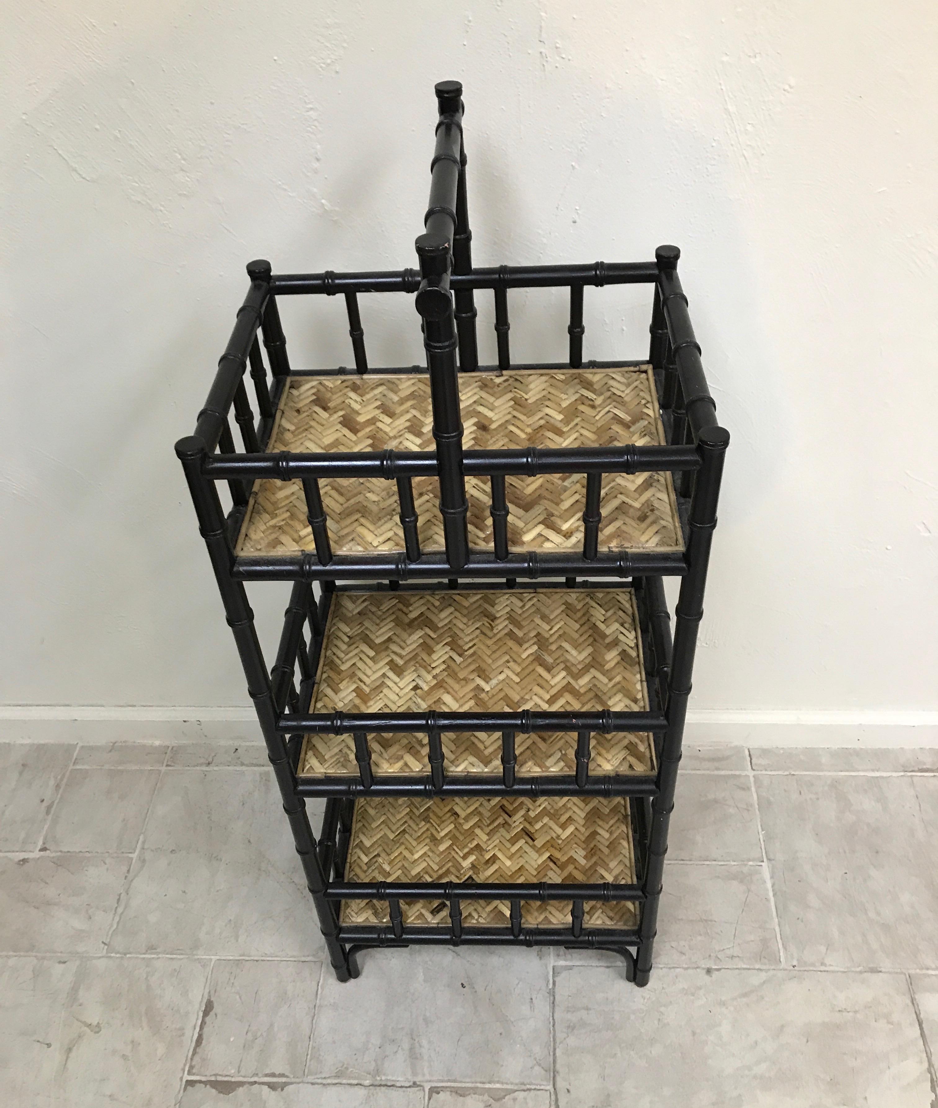 Black and natural faux bamboo étagère with woven bamboo shelves.