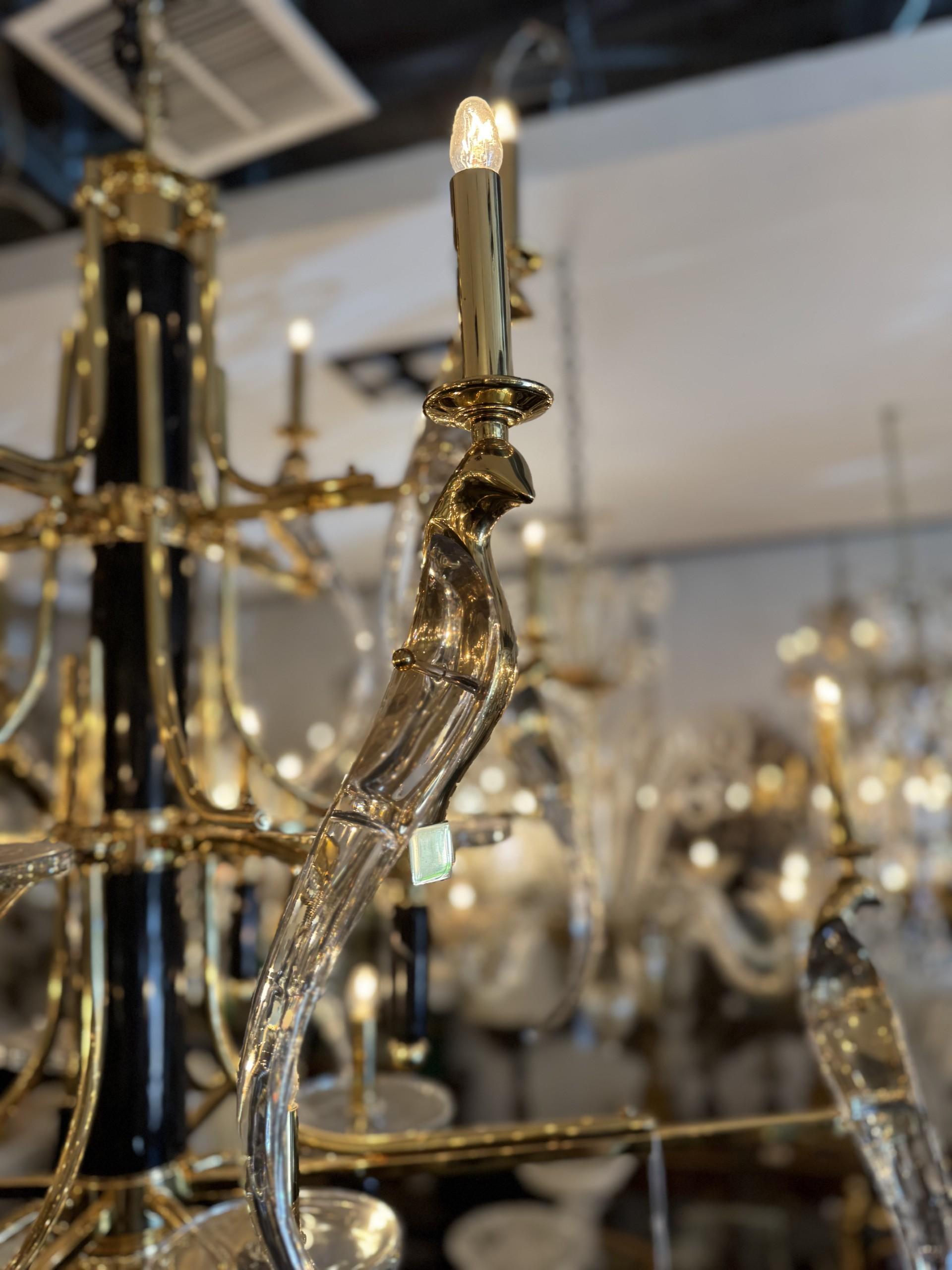 Impresionante y exclusiva Lámpara de araña con brazos de hierro dorado en tono oro y marco de mármol con detalles de pájaros de cristal transparente. Las luces estilo vela añaden un toque clásico, mientras que los pájaros esculpidos aportan un toque