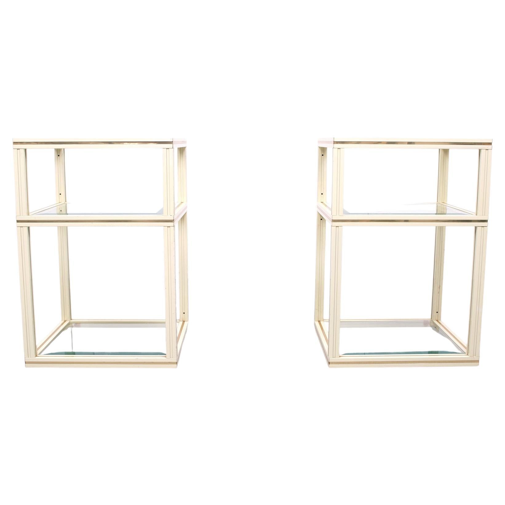 Two three tier side tables Creme color aluminum with brass details. Beveled glass tops. signed on top of the tables Pierre Vandel Paris .
lots off storage space. Normal wear and tear.
  