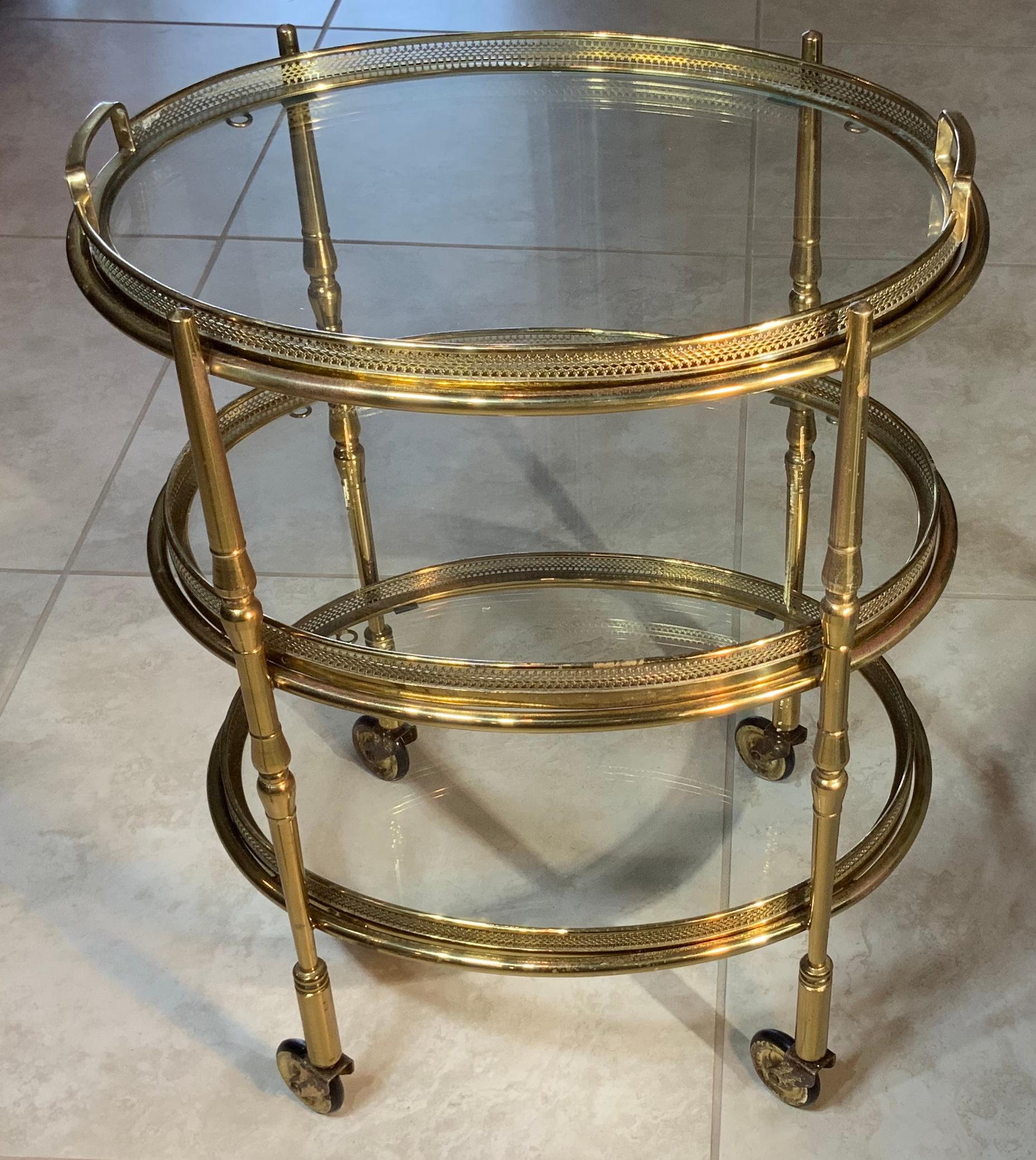 This elegant oval shape vintage rolling desert table made from three removable tray
Each tray has decorative brass trimming around and the top tray has utilitarian handles. Four straight legs with small wheels on the bottom.
Classic funky addition