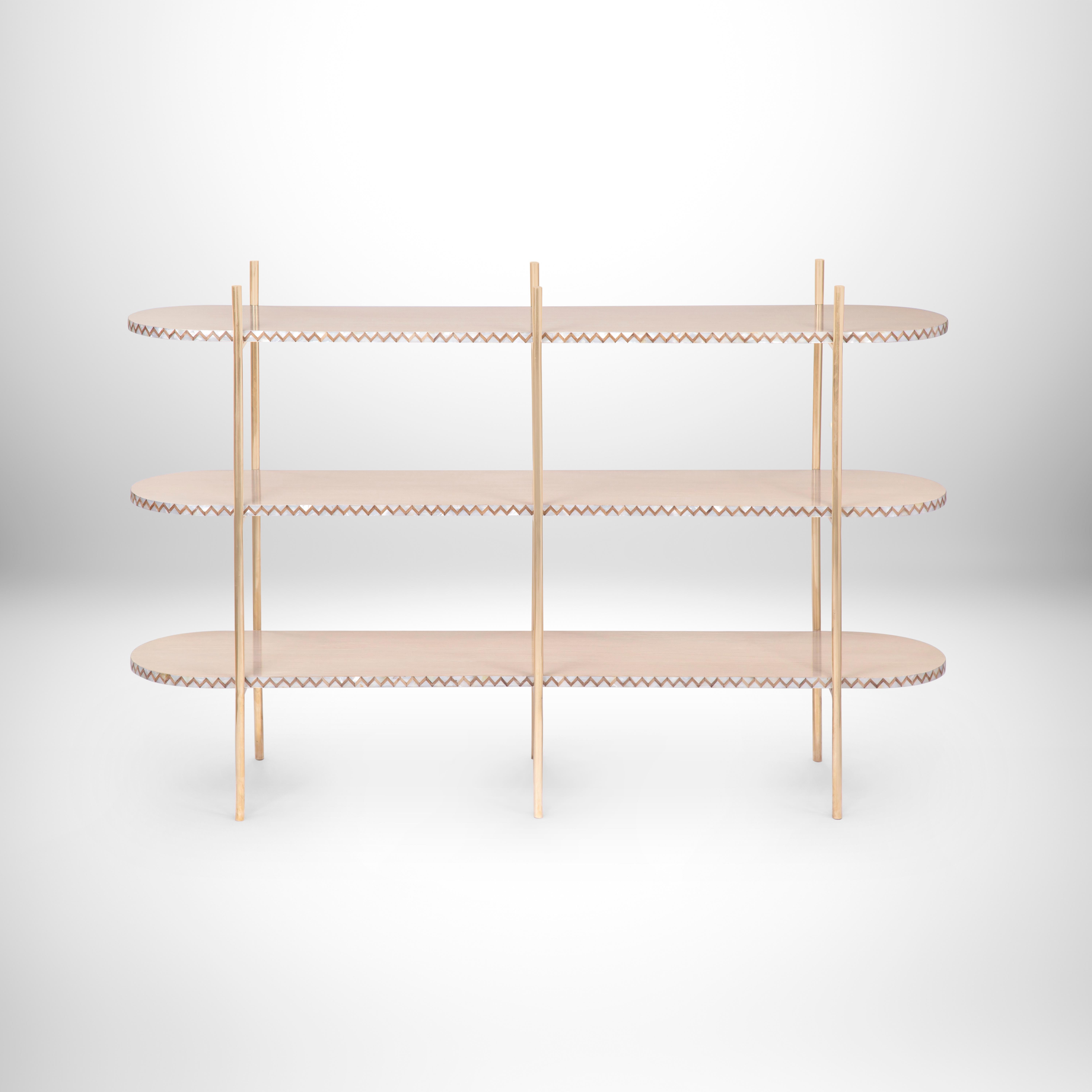 Console à trois niveaux, avec nacre plaquée à la main, placage de chêne et cadre en laiton.
Tout comme le véritable horizon, cette console minimale Art déco est simple mais inspirante. Le placage de chêne contraste avec la nacre incrustée à la