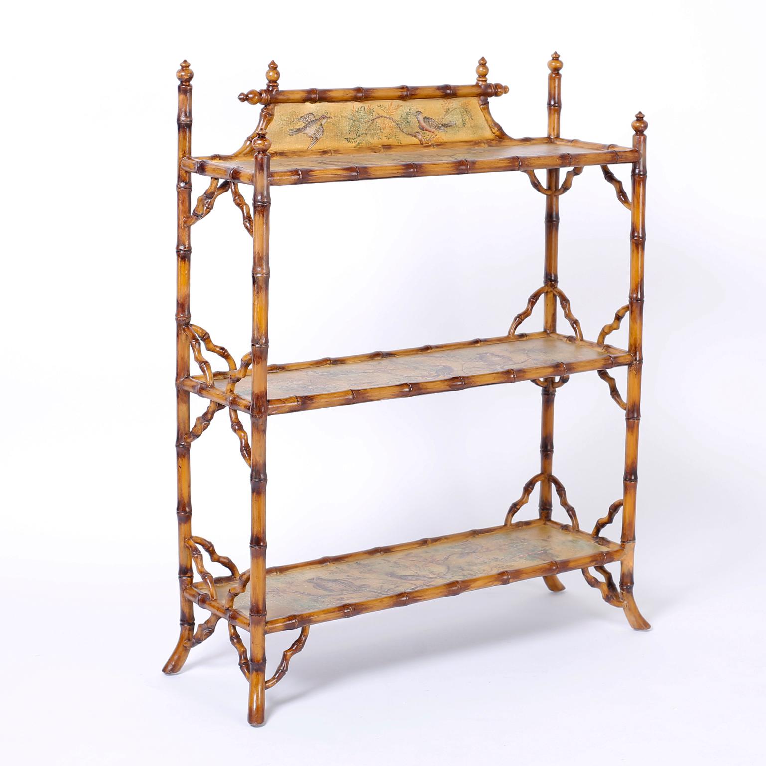 Three-tiered faux bamboo étagère with turned finial and splayed feet. The shelves and backsplash are decorated with decoupage whimsical birds, trees and flowers.