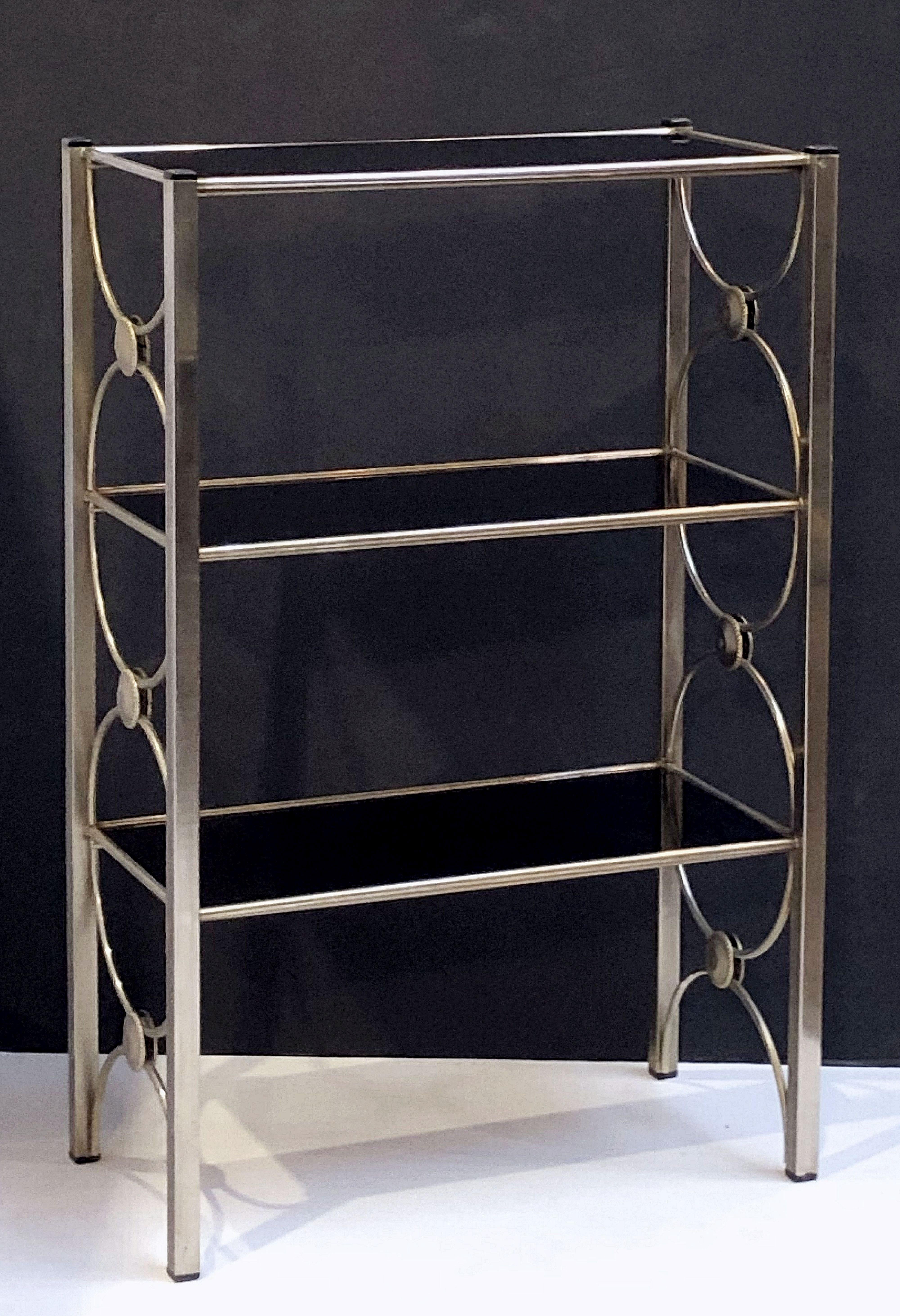 A fine English open etagere or display shelf, featuring a brushed metal frame and three removable rectangular shelves of black glass. Glass shelves can be reversed for a different look.

Dimensions: H 36 inches x W 23 1/2 inches x D 12 inches