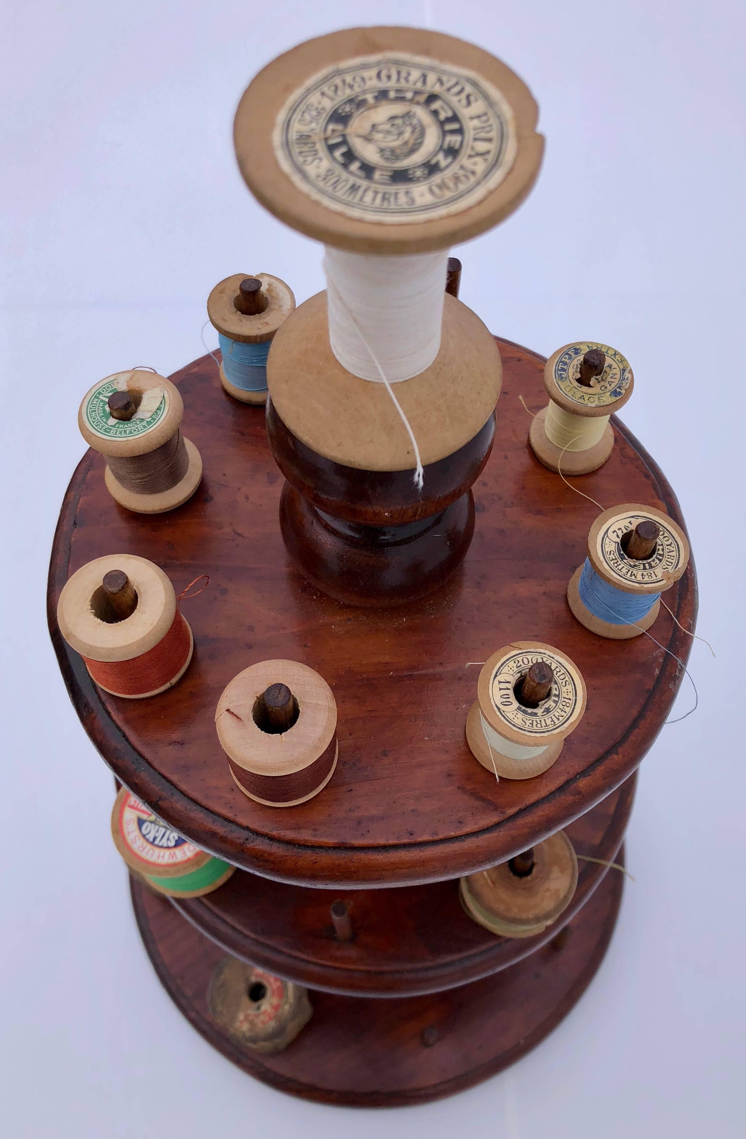 This lovely three-tiered wooden spool caddy holds over 25 spools of thread and has beautiful curved detail. The shown wooden spools are included in the lot. Displayed on a table to keep your spools of thread handy or re-purposed to hold rings or