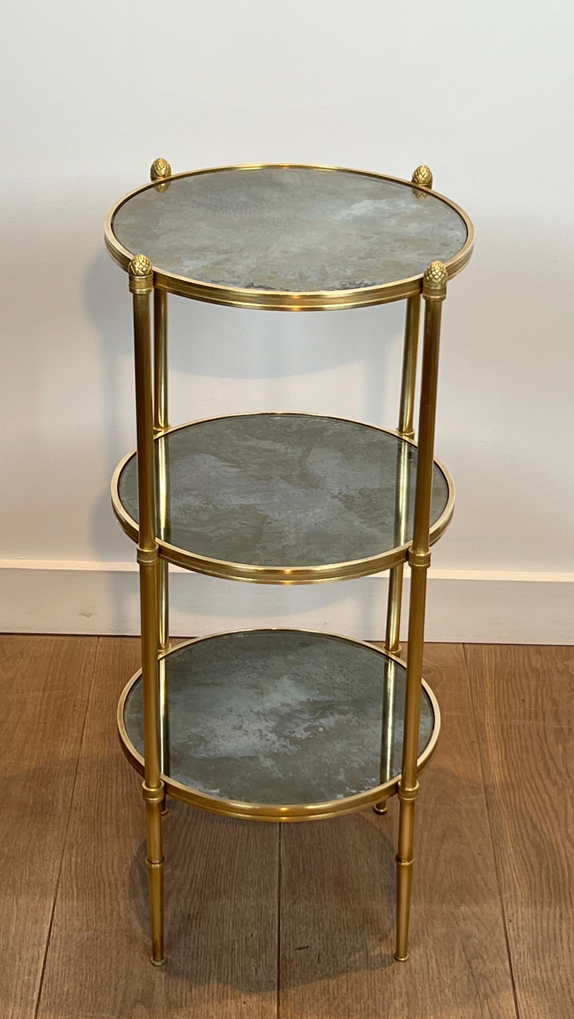 This beautiful three tiers round gueridon is made of bronze and brass with eglomized mirror tops. This is a French work by Maison Baguès. Circa 1940