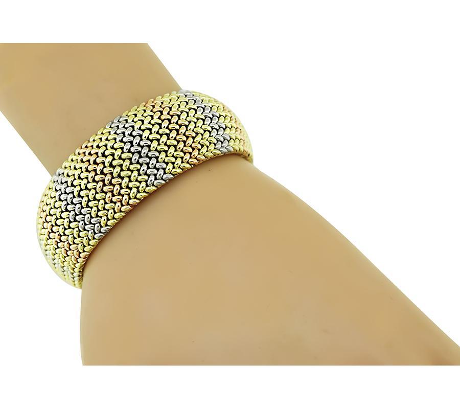 This is an elegant three tone 14k yellow, pink and white gold bracelet. The bracelet features lovely weave motif. The bracelet measures 7 1/4 inches and 22mm in width. The bracelet is stamped 14K and weighs 75.7 grams.