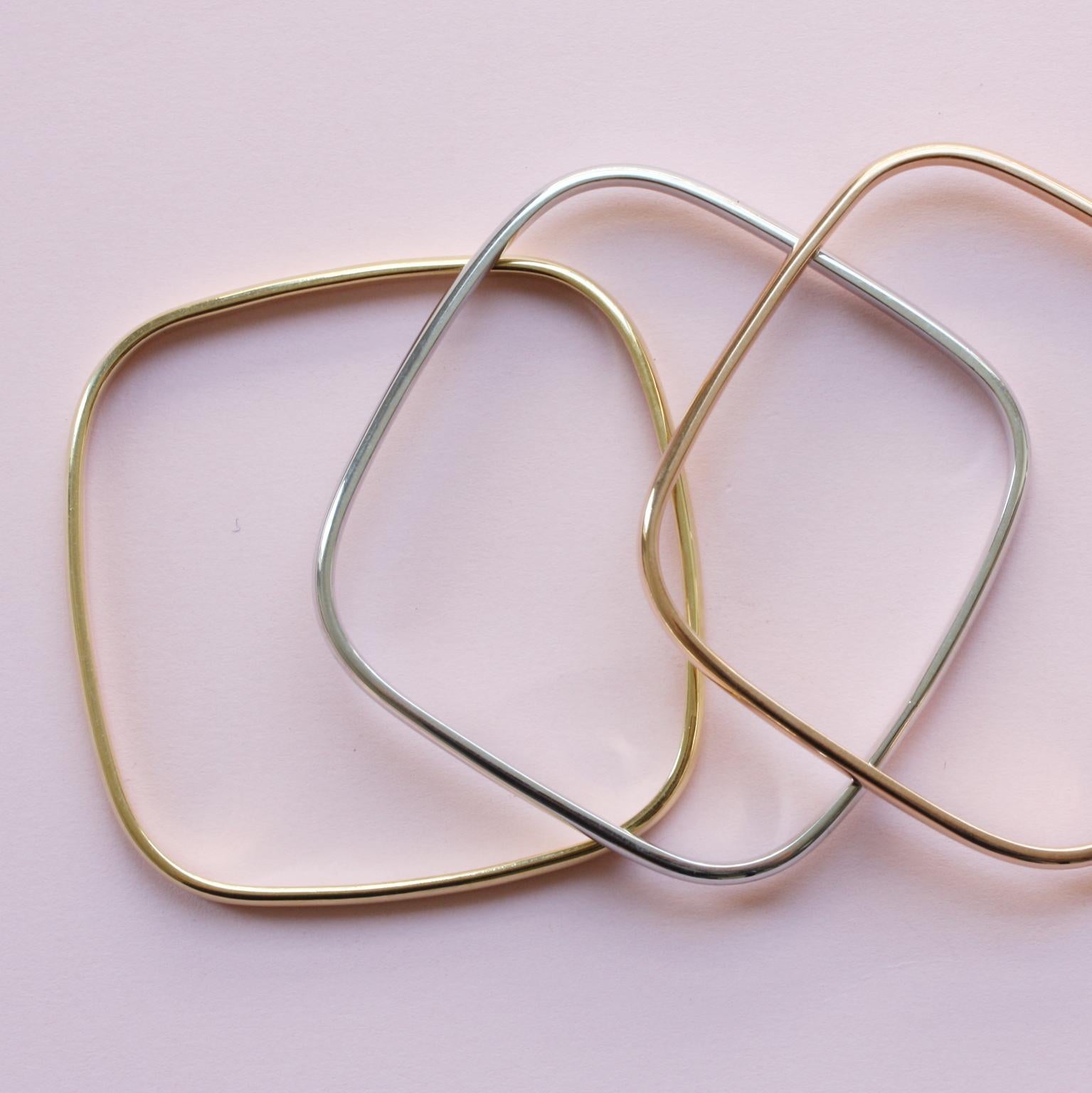 Three heavy 18 carat gold bangles, one yellow, one pink and one white gold, square with rounded corners, France, circa 1970.

weight: 83.03 grams
size: 6.2 x 6 cm.