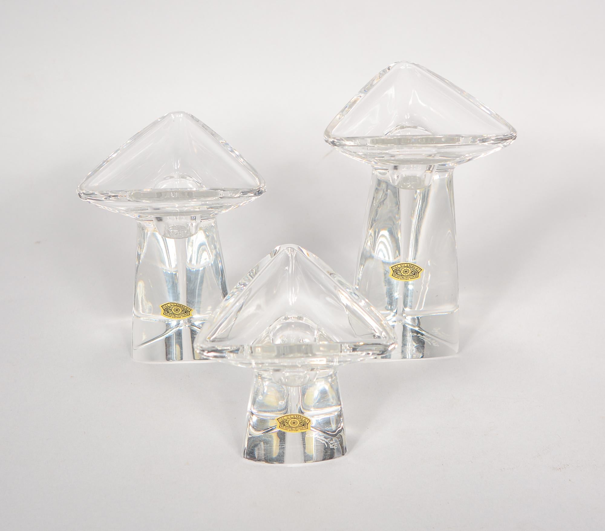 Set of three Tricorne crystal candlesticks made by Val St Lambert of Belgium. These were designed in 1956 by Peter Muller-Munk. All three have an etched signature on the bottom as well as retaining the original labels. The dimensions given are for