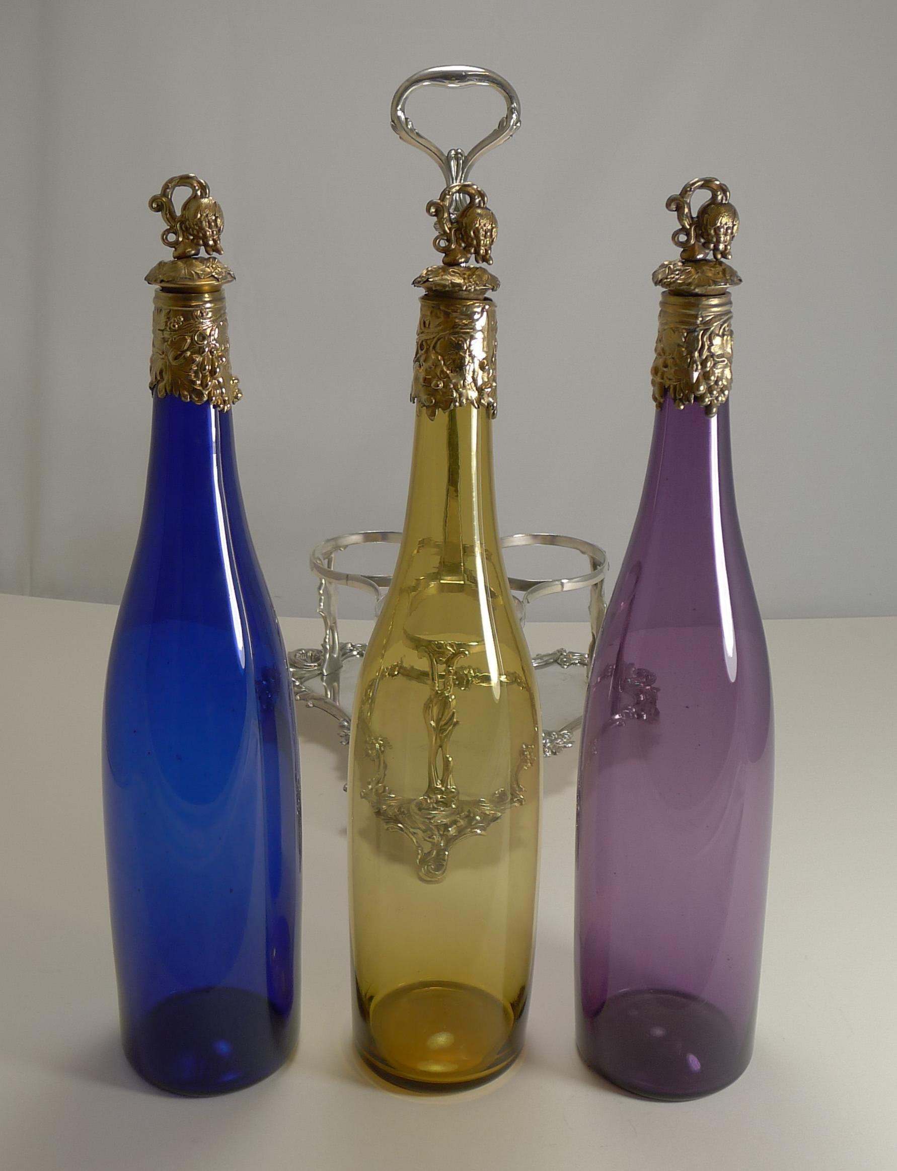 A magnificent set of three late Victorian colored glass decanters, all with polished pontil marks on the underside showing that they were individually hand blown; one in golden yellow, one in Amethyst and one in cobalt blue.

Each is topped with a