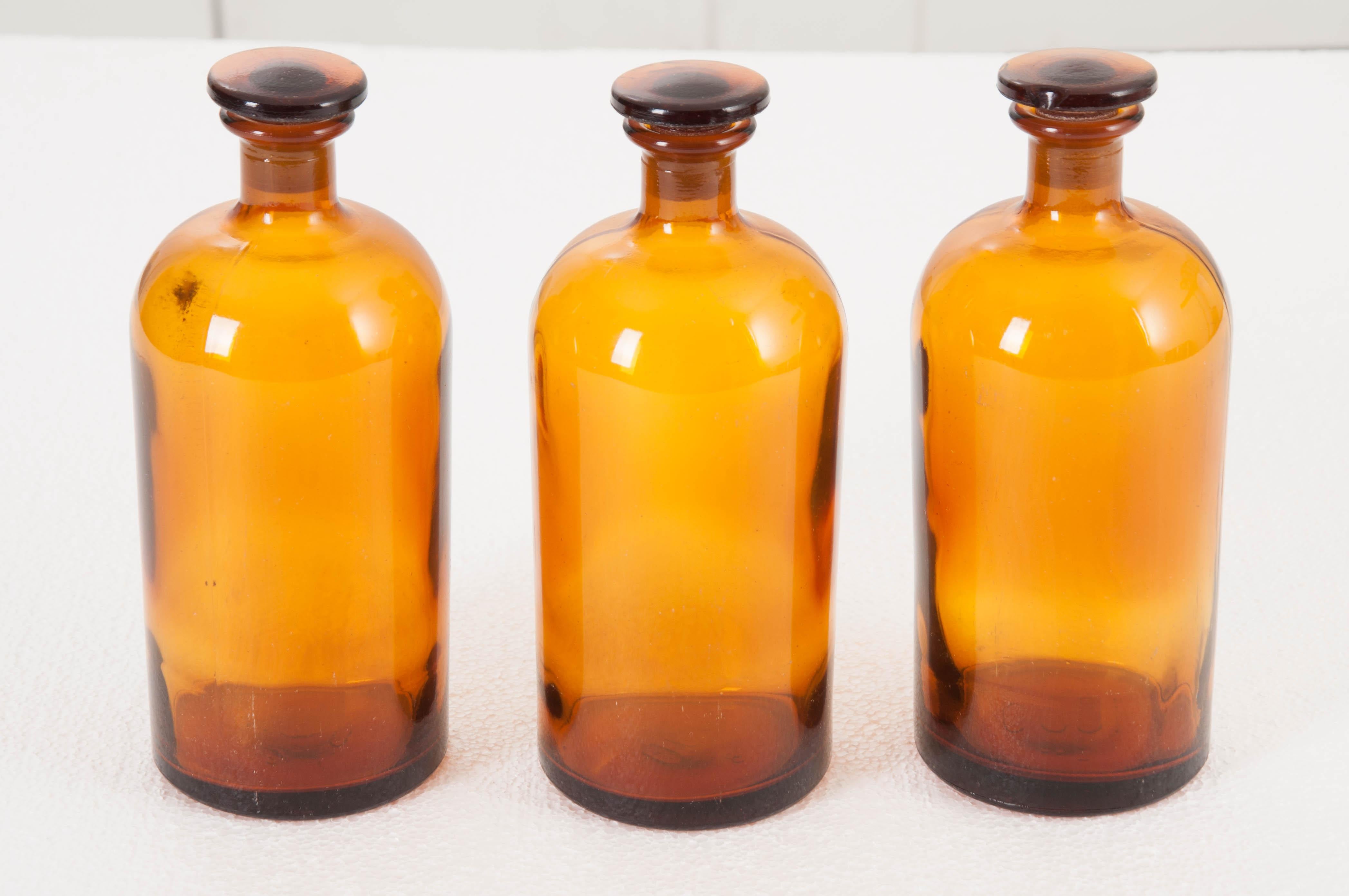 A fantastic set of vintage amber glass apothecary jars. These French jars were made towards the beginning of the 20th century. They each have lids that will protect their contents from dust and/or evaporation. The jars are available for individual