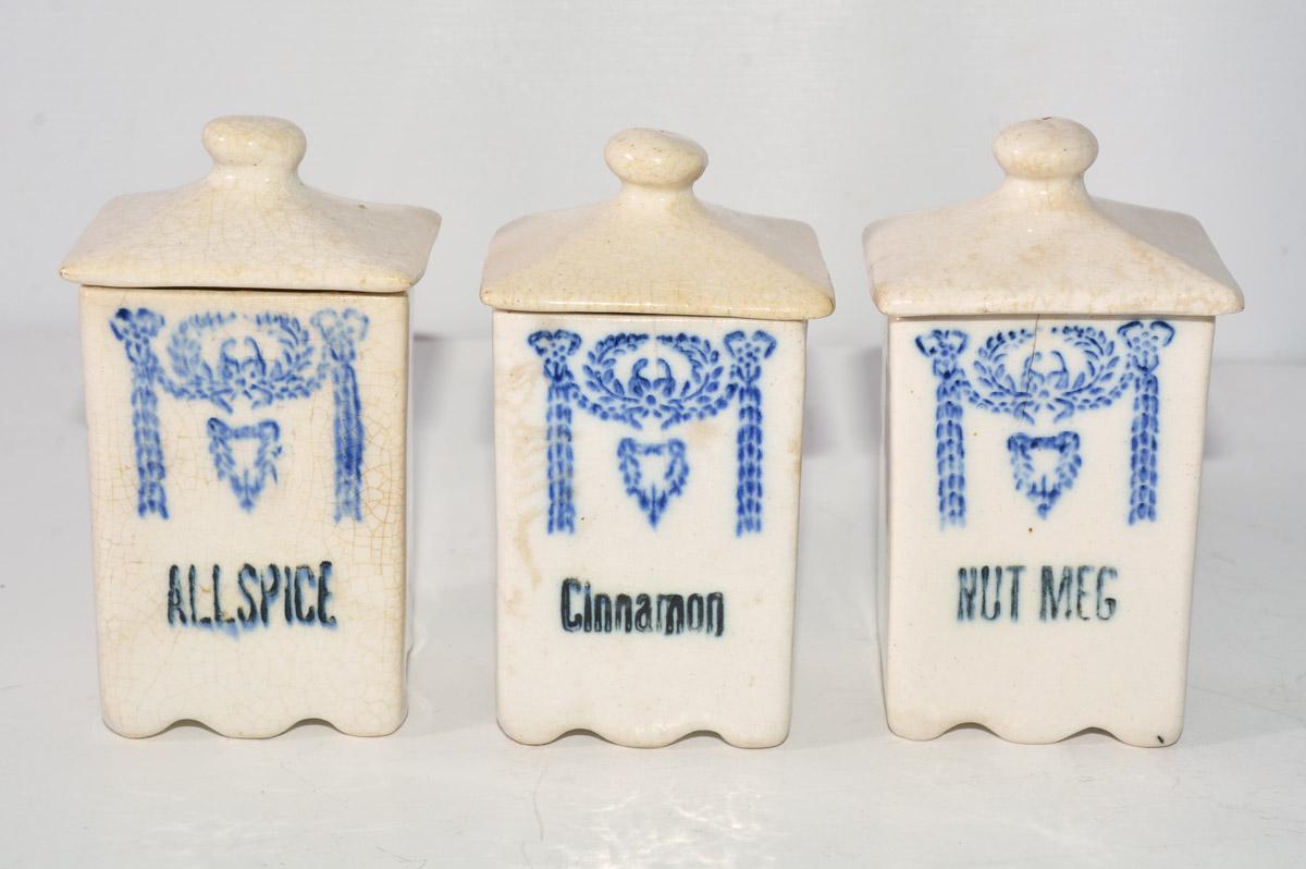 The three small vintage canisters have labels reading Allspice, Cinnamon and Nutmeg under blue decorative swags.