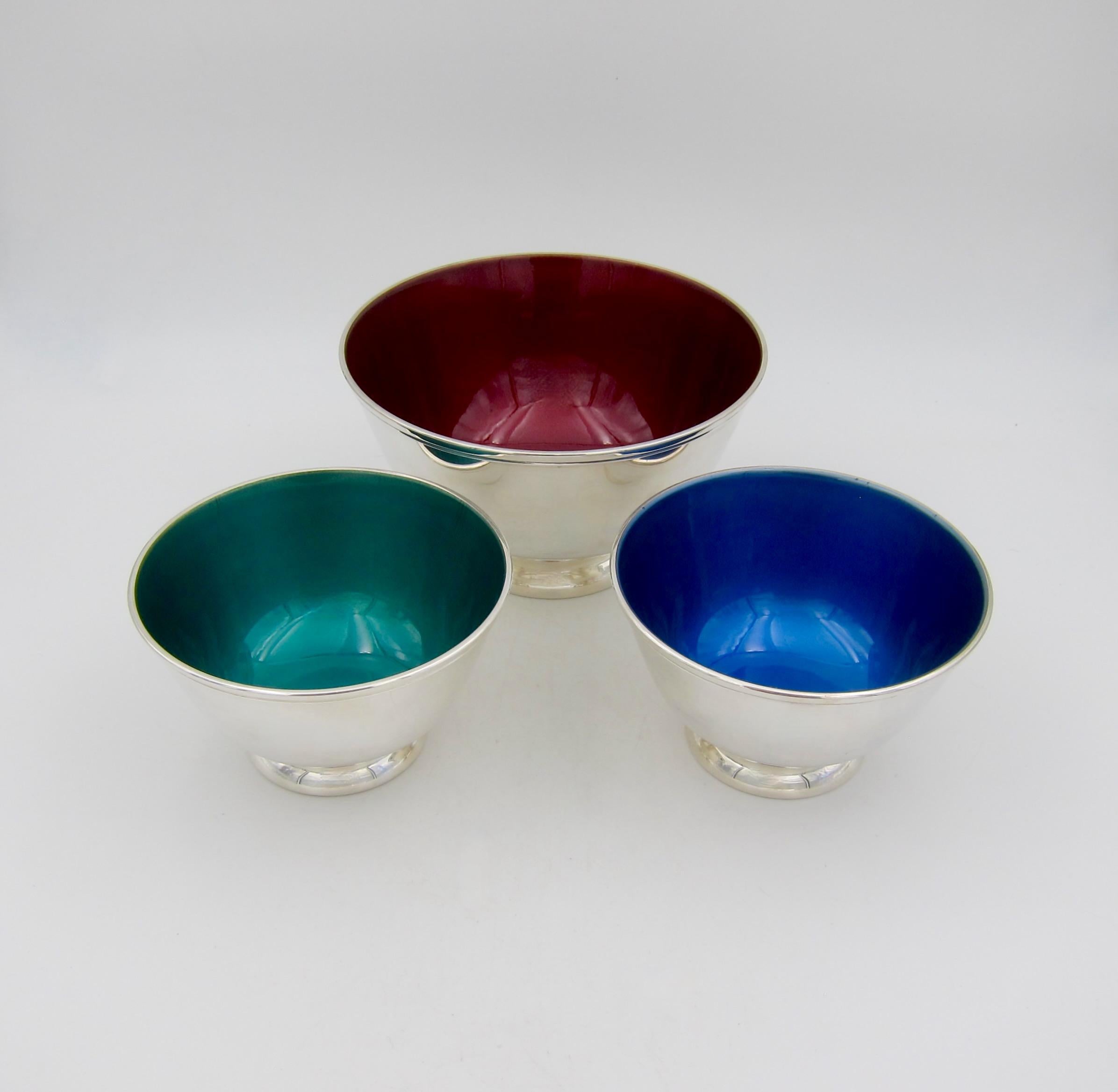 A set of three American footed bowls in silver-plate with gorgeous jewel-toned enamel interiors from Towle Silversmiths of Newburyport, Massachusetts. The colorful vintage bowls were introduced in the 1960s as stylish and versatile accents for the