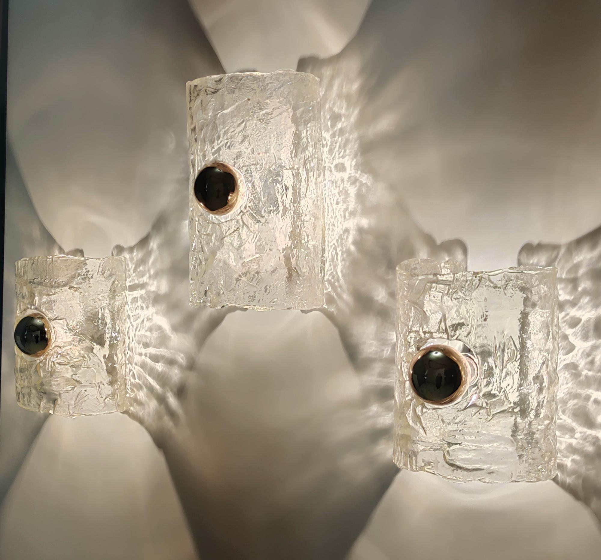 1970s.
This is a wonderful set of three appliqués. 
They are made in Murano glass with an ice effect and varnished metal. 
These are vintage wall lights, therefore they might show slight traces of use, but they can be considered as in very good