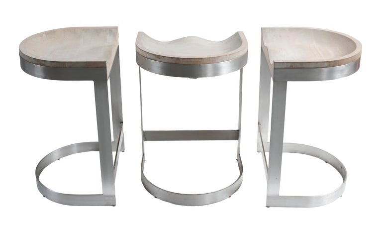 Three striking vintage modernist saddle form barstools by Warren Bacon. Sculpted white oak seats on cantilevered brushed aluminum bases. Heavy and sturdy construction, circa 1970.