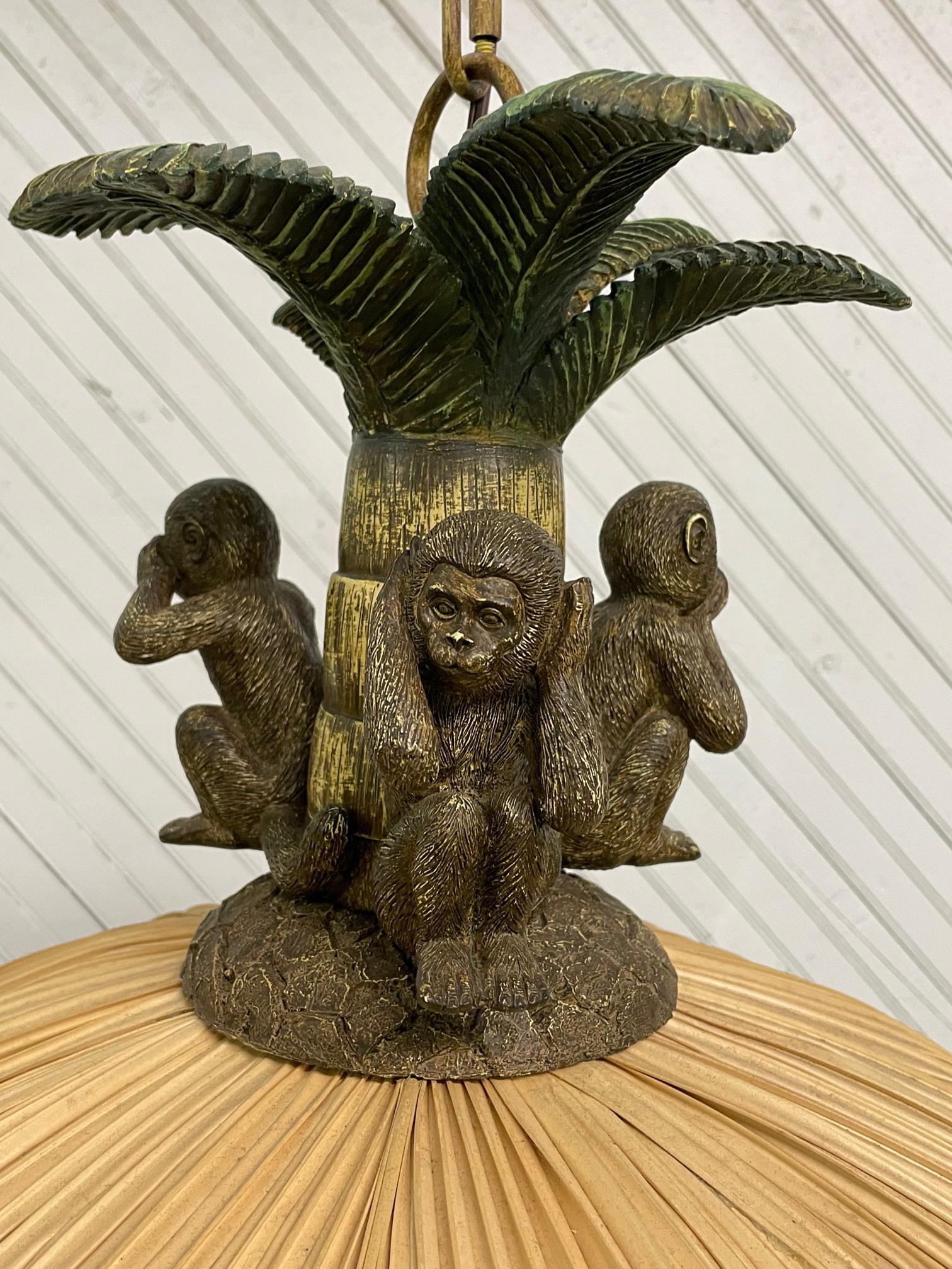 Tropical style hanging lamp features the three famous monkeys signifying hear no evil, speak no evil, and see no evil. Pleated paper shade and palm tree top. Very good condition with no noticeable imperfections.

 