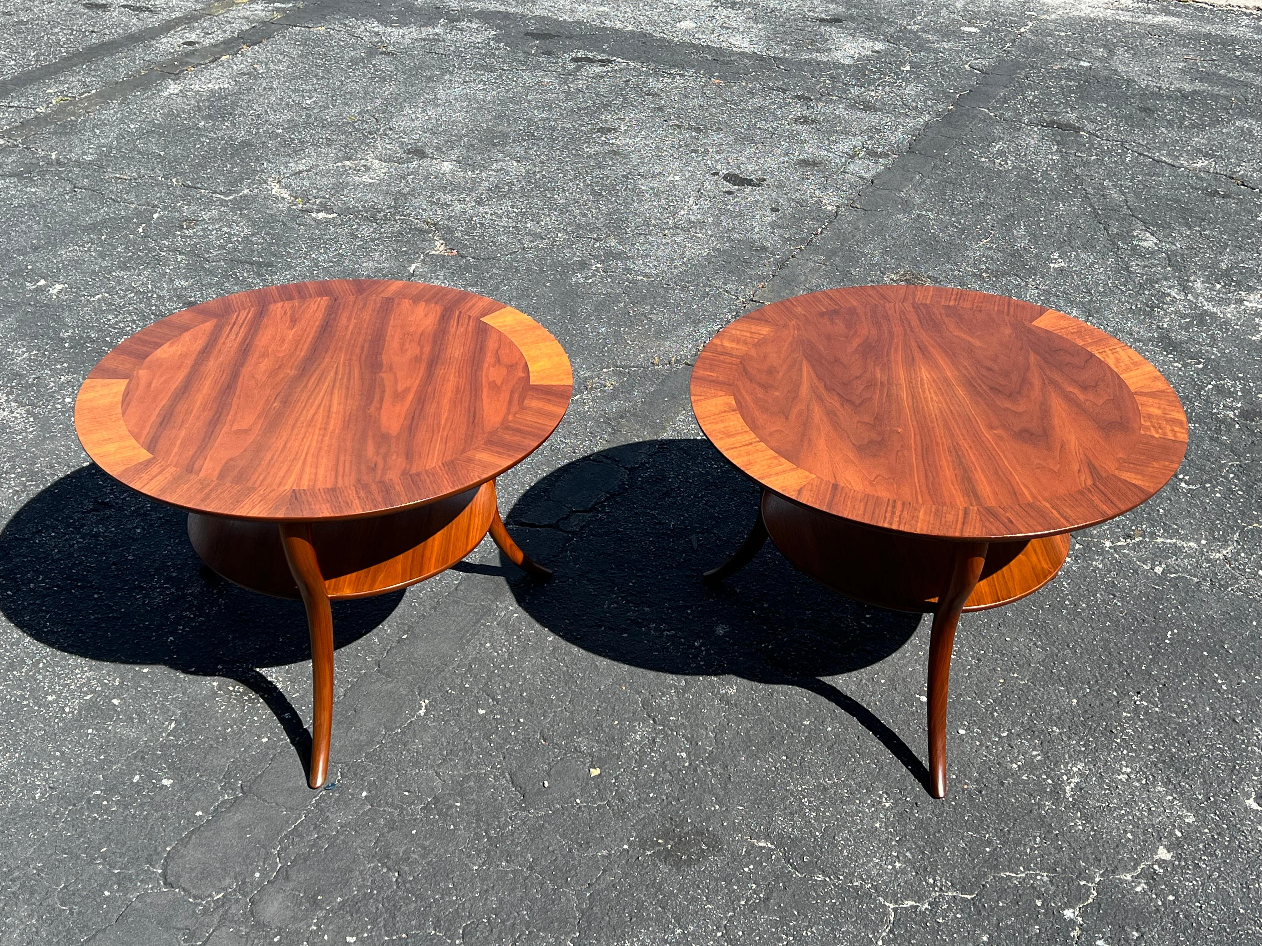 A classic T.H.Robsjohn-Gibbings for Widdicomb lamp or occasional tables with cabriolet style legs in walnut, with lower shelf. Elegant and stylish, restored. Walnut has beautiful graining. Sold invidually for $3,800 or $6,500 for the pair.