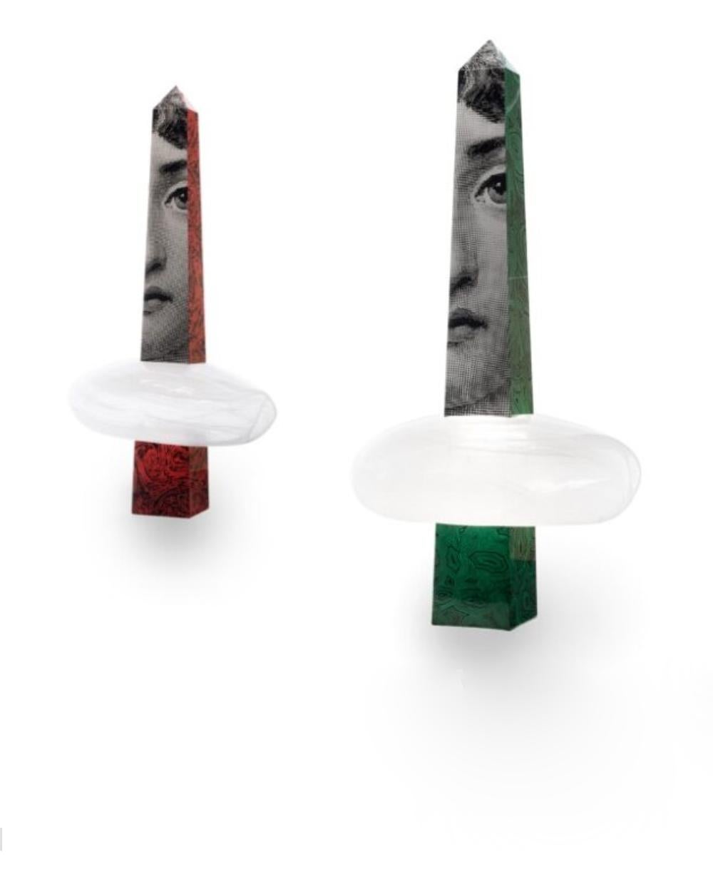 Designed by the iconic Italian decorative firm, Atelier Fornasetti, Through The Clouds takes inspiration from daydreaming. Delicate glass clouds float above the viewer, suggesting divine perspective. Obelisks protrude from the clouds, nodding to the