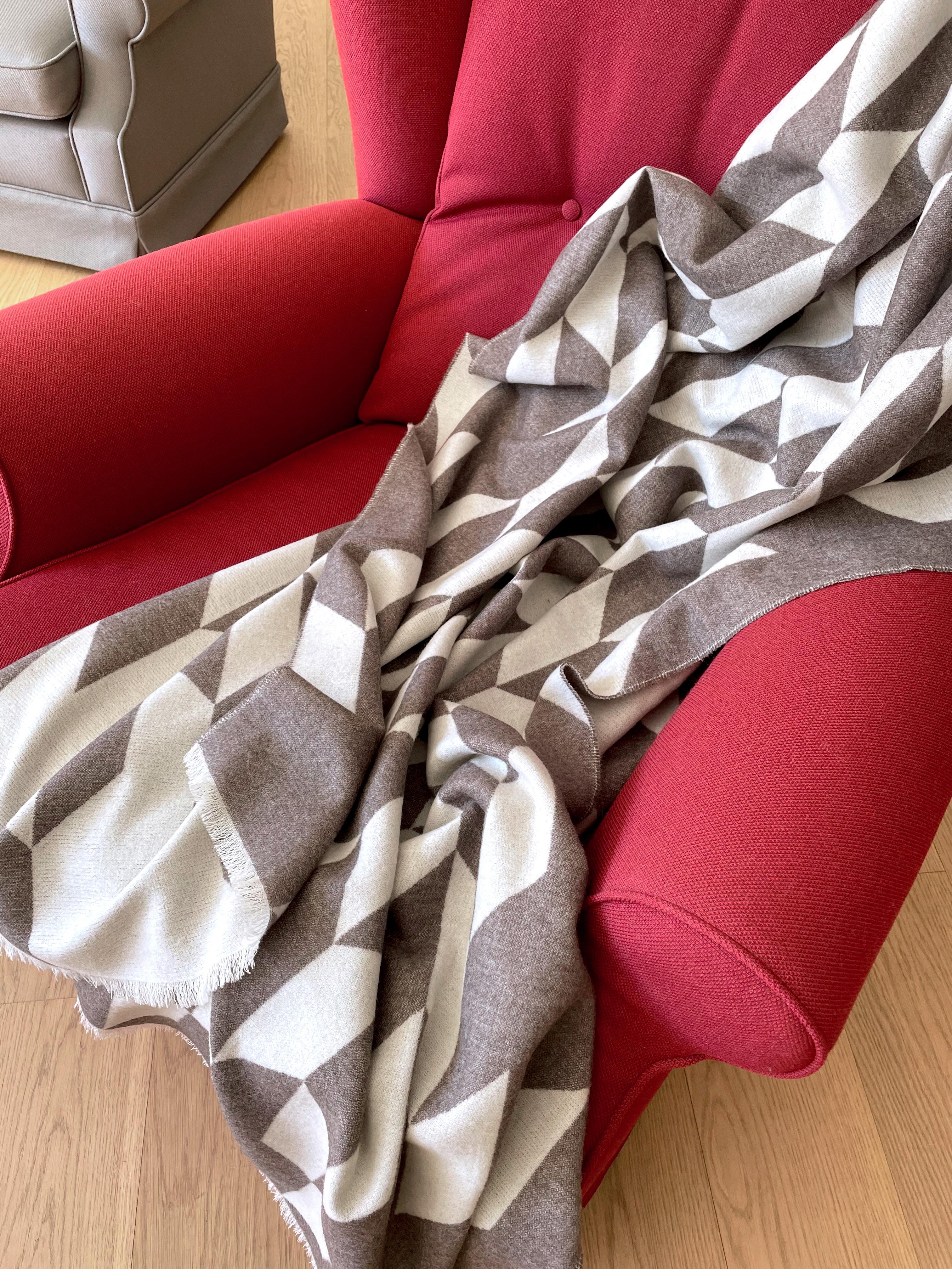 Entworfen in Berlin von Catharina Mende, gewebt aus 100% extrafeiner Merino in Schottland: Diese luxuriöse und schmeichelhafte Decke ist die perfekte Kombination aus Farbe, Form und Material für jede Tages- und Jahreszeit. Dieses exquisite Stück