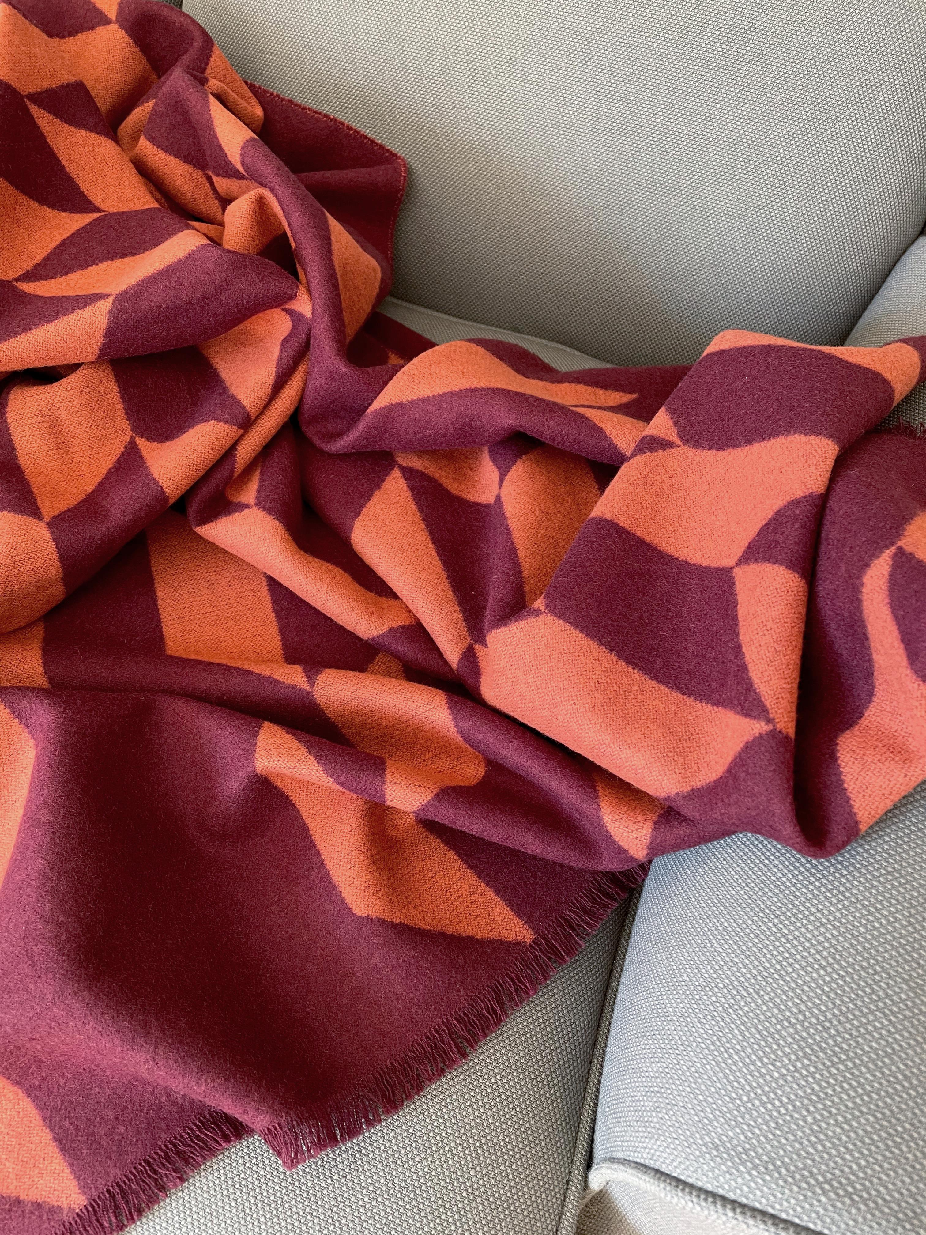 Entworfen in Berlin von Catharina Mende, gewebt aus 100% extrafeiner Merino in Schottland: Diese luxuriöse und schmeichelhafte Decke ist die perfekte Kombination aus Farbe, Form und Material für jede Tages- und Jahreszeit. Dieses exquisite Stück