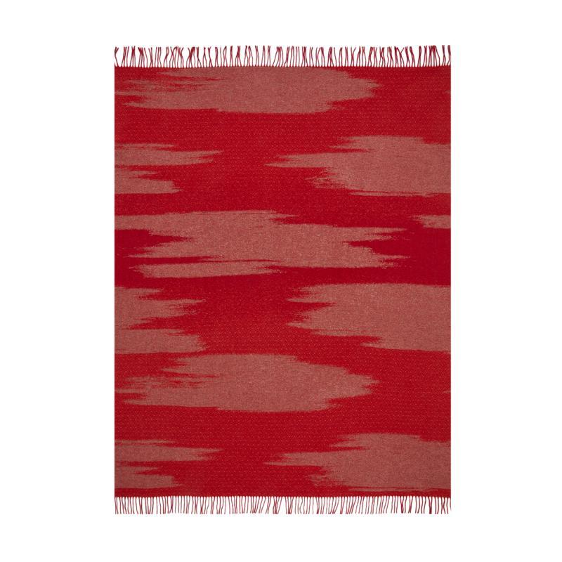 The KAMI collection is composed of yarn-dyed jacquard throws with a large golden cloud pattern, metallic threads, and short fringes. This throw is a vibrant red colour and the cloud designs contrasted with the geometric stitiching lend a sense of