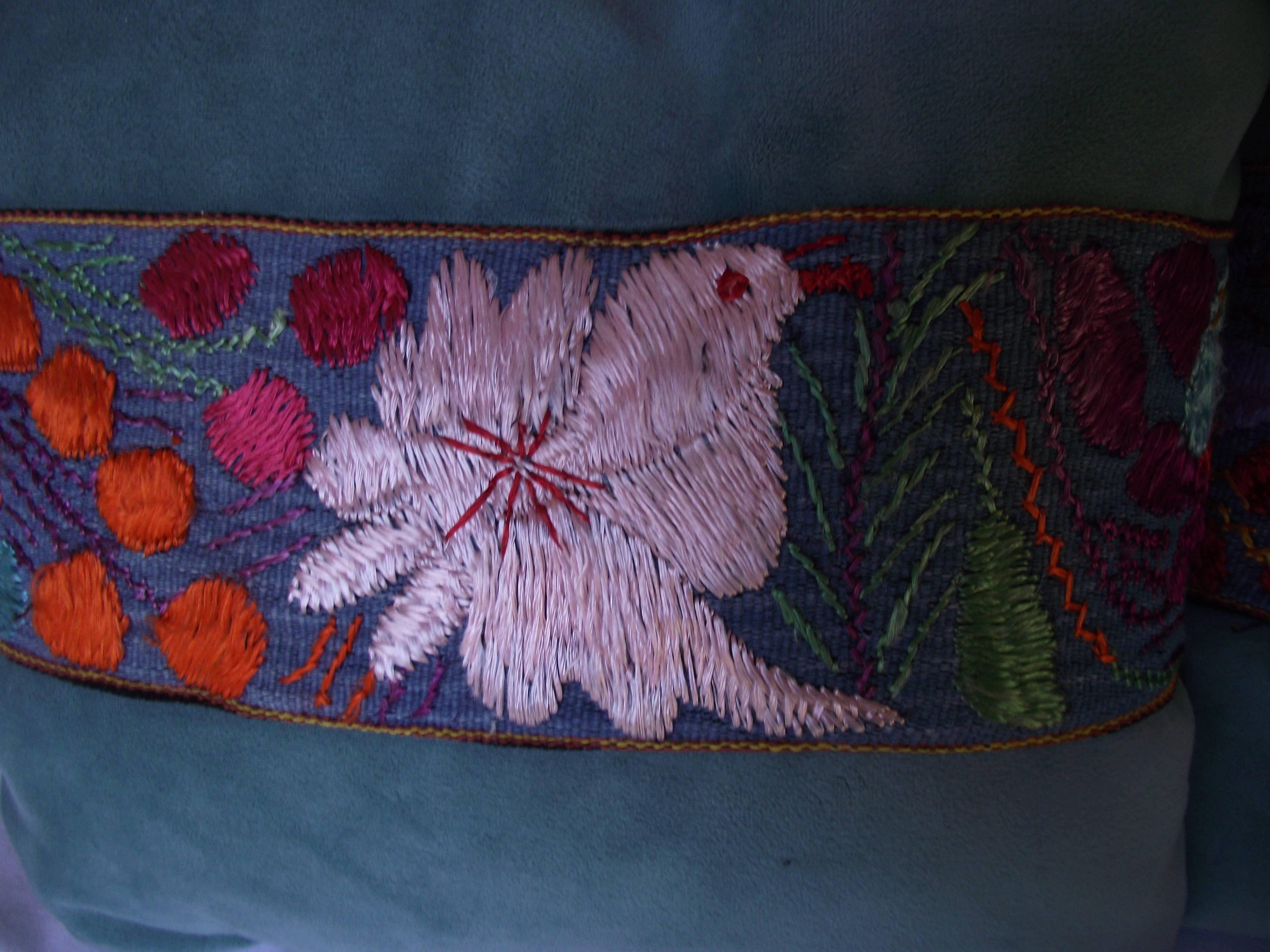 This pair of pillows are trimmed with pieces from an antique Peruvian scarf. One features a bird or flower design and the other has a goat image.
