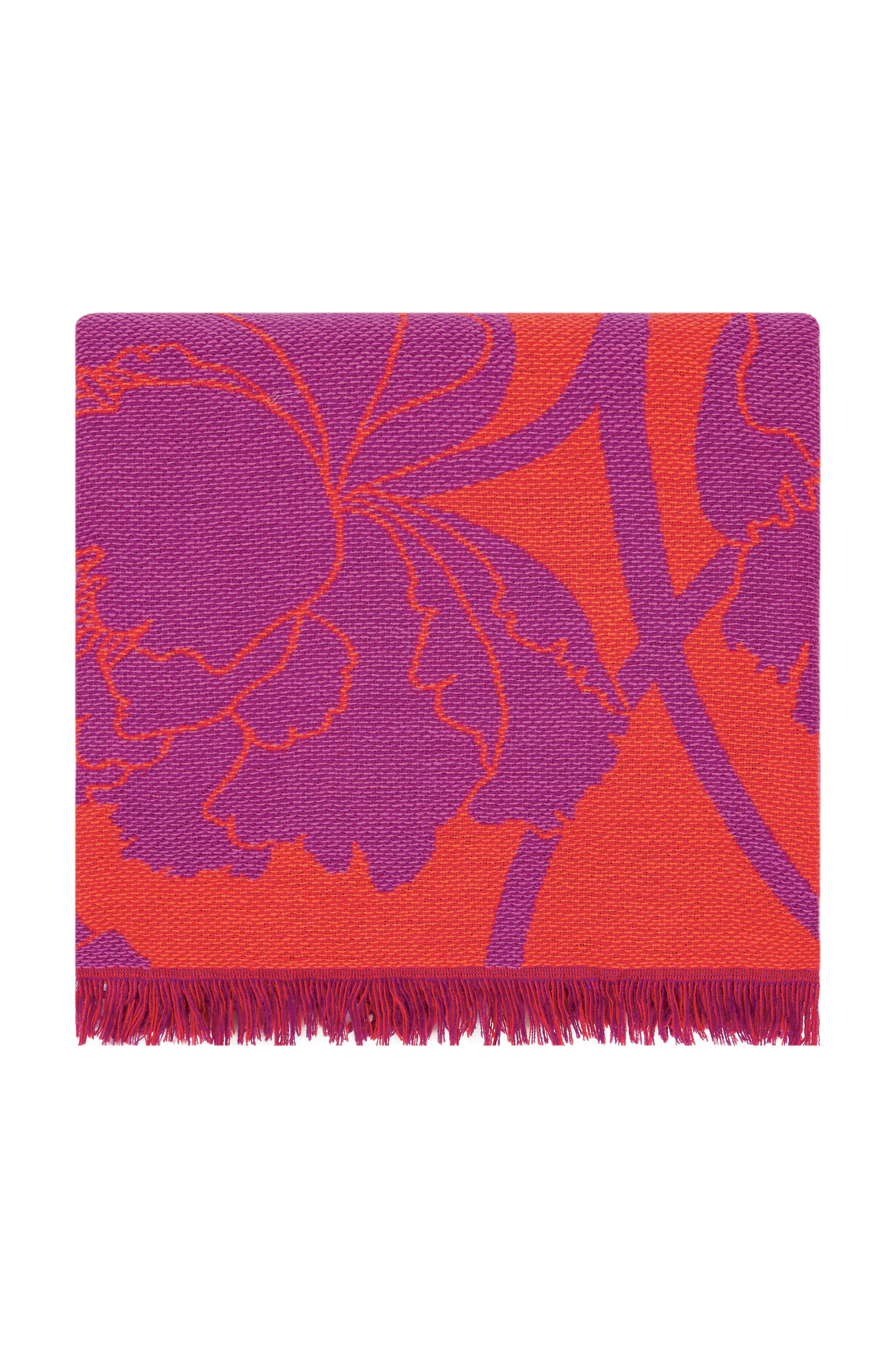 This is a vibrant pink and orange jacquard throw decorated with a pattern of large, elegant peonies and short fringes. The peony flower is a Japanese symbol for good fortune.