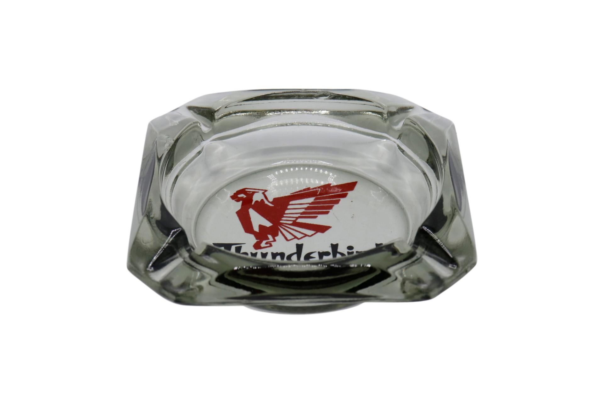 A pair of square glass ashtrays from the Thunderbird Hotel of Las Vegas, Nevada. The center is printed with their 1950's logo and reads “Thunderbird Hotel, Las Vegas, Nev”. The Thunderbird hosted a number of noted entertainers and production shows