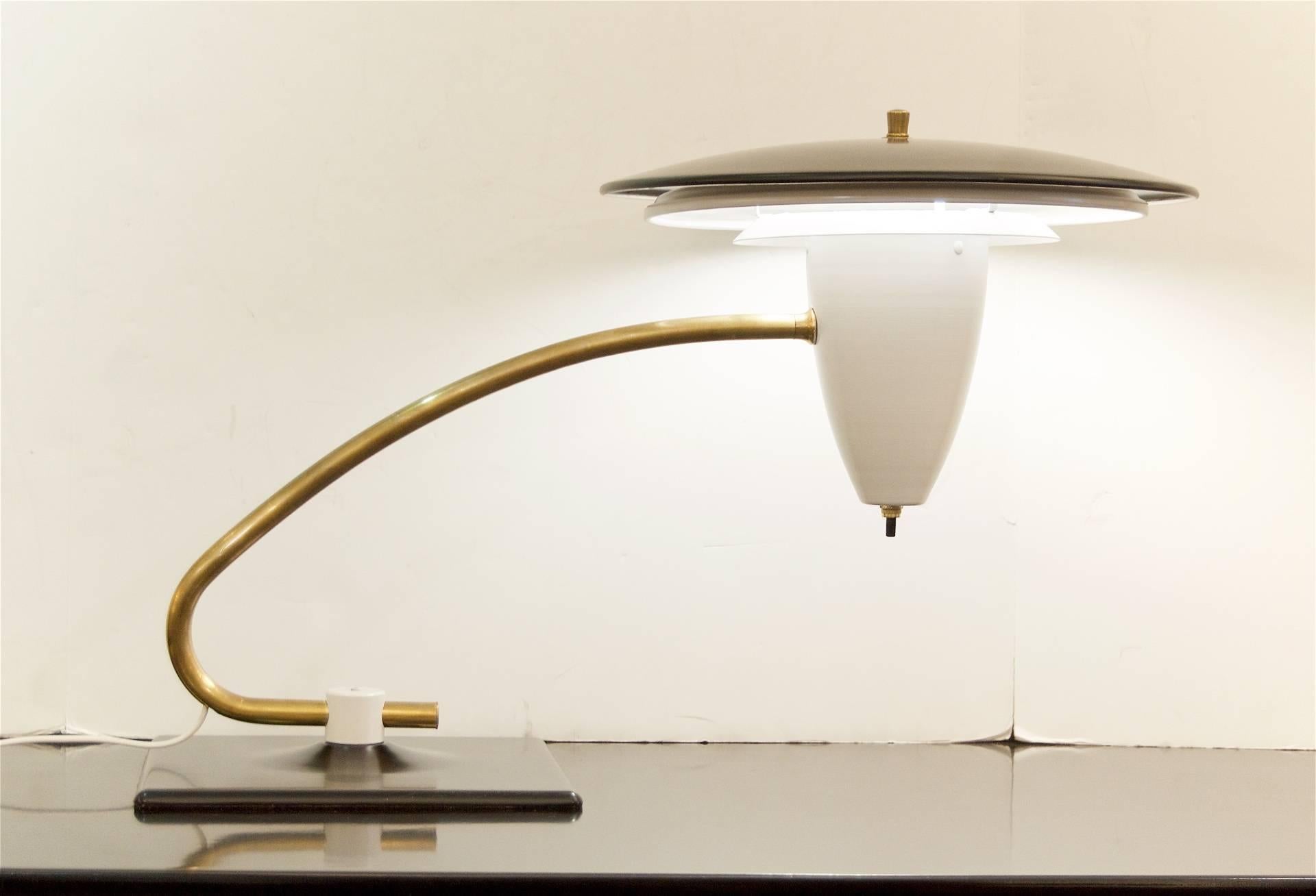 Excellent midcentury desk lamp, with black and white enameled flying disc diffusers on a brass swivel arm.

New wiring and newly lacquered. Original condition to brass.

Measures: 14