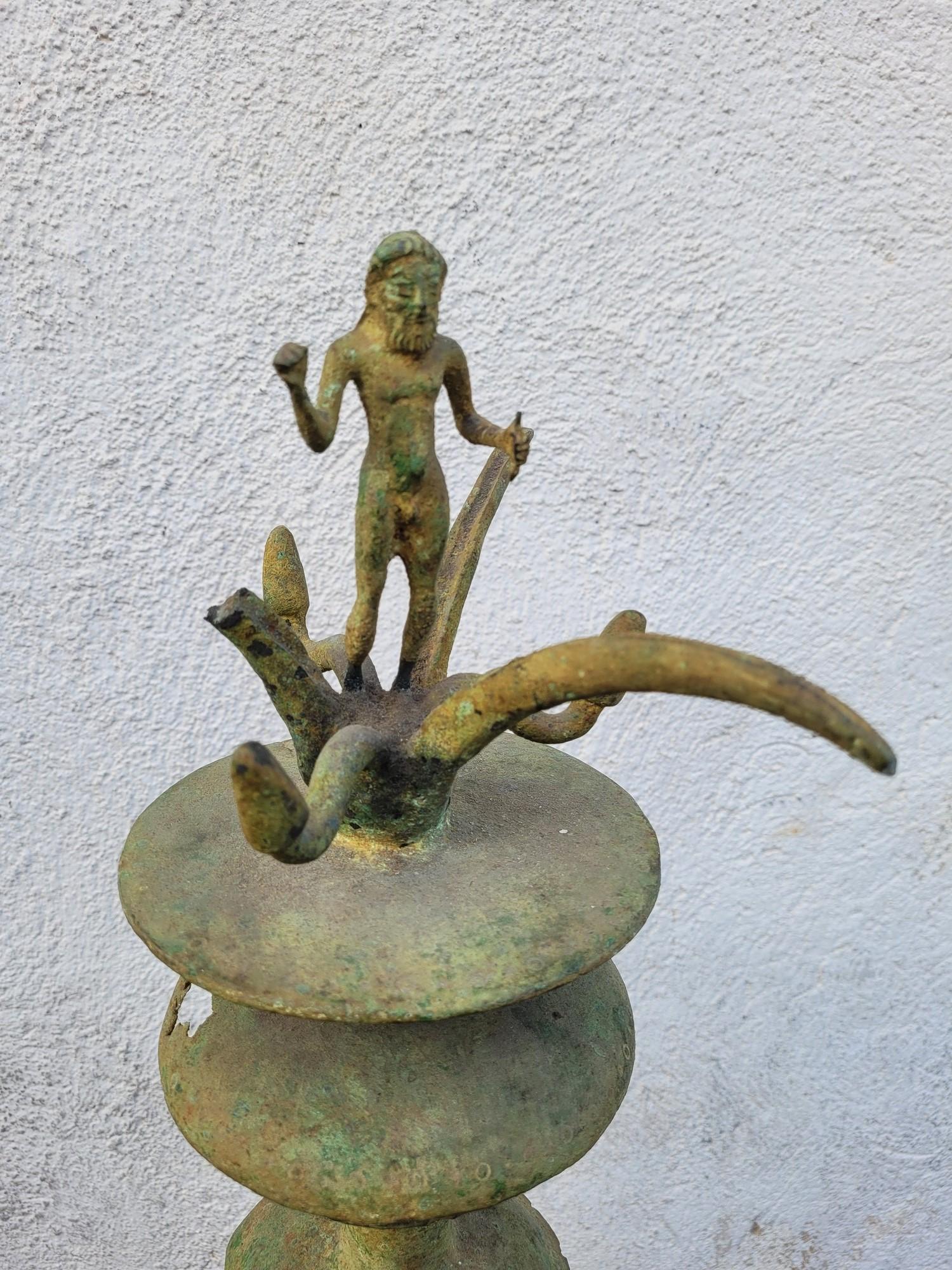 Thymiaterion oder Räuchergefäß aus patinierter Bronze, verziert mit einer zentralen Figur, wahrscheinlich einer Tänzerin, die auf einem dreibeinigen Fuß mit Löwentatzen steht, und kleinen Löwenskulpturen
Über seinem Kopf endet eine Säule mit