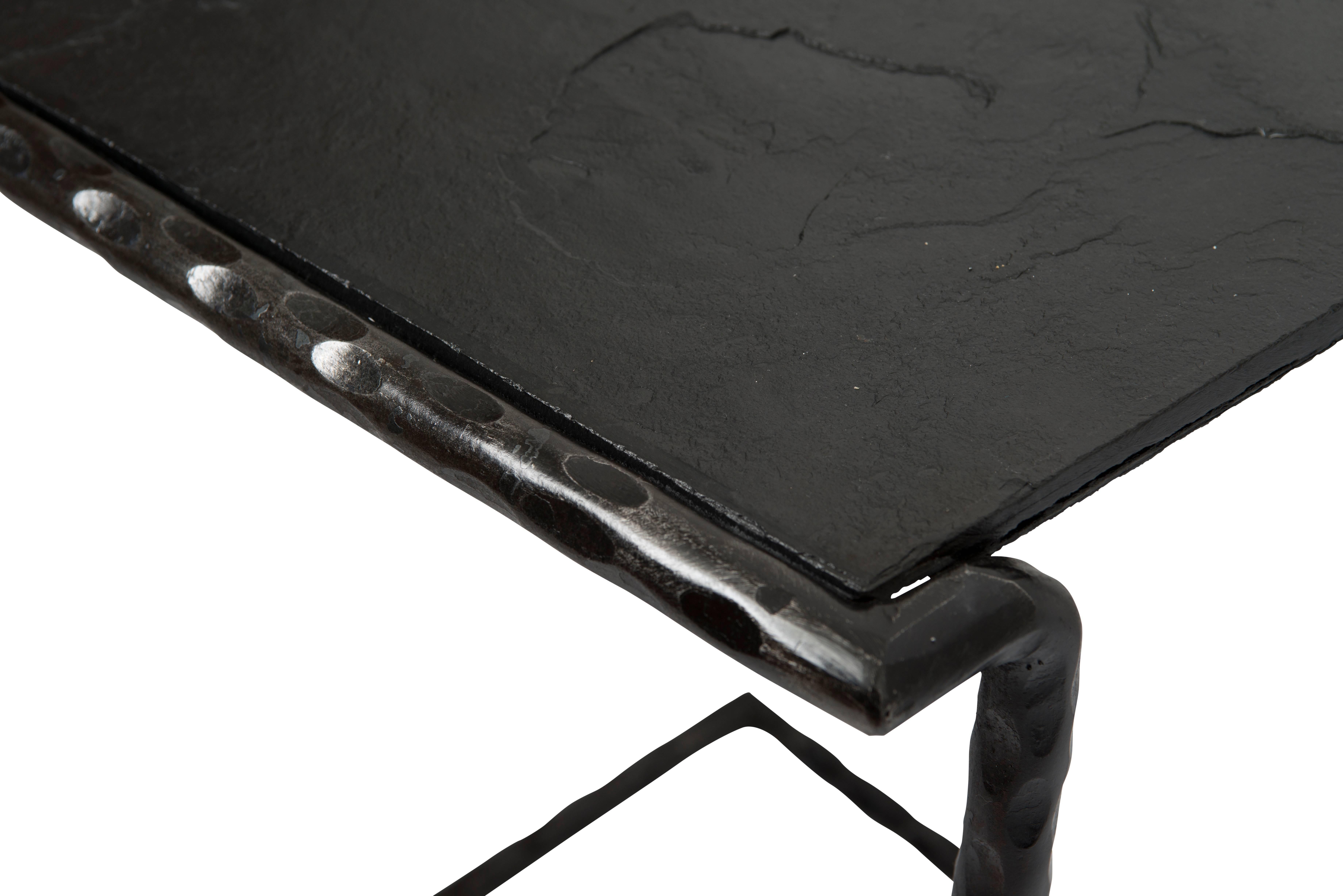 Steel frame with a slate top. The black slate has an uneven top surface. All slate is hand cut. A fun element to the design is that none of the cut lines of the table surface are parallel to each other. The footprint of the table will mimic the
