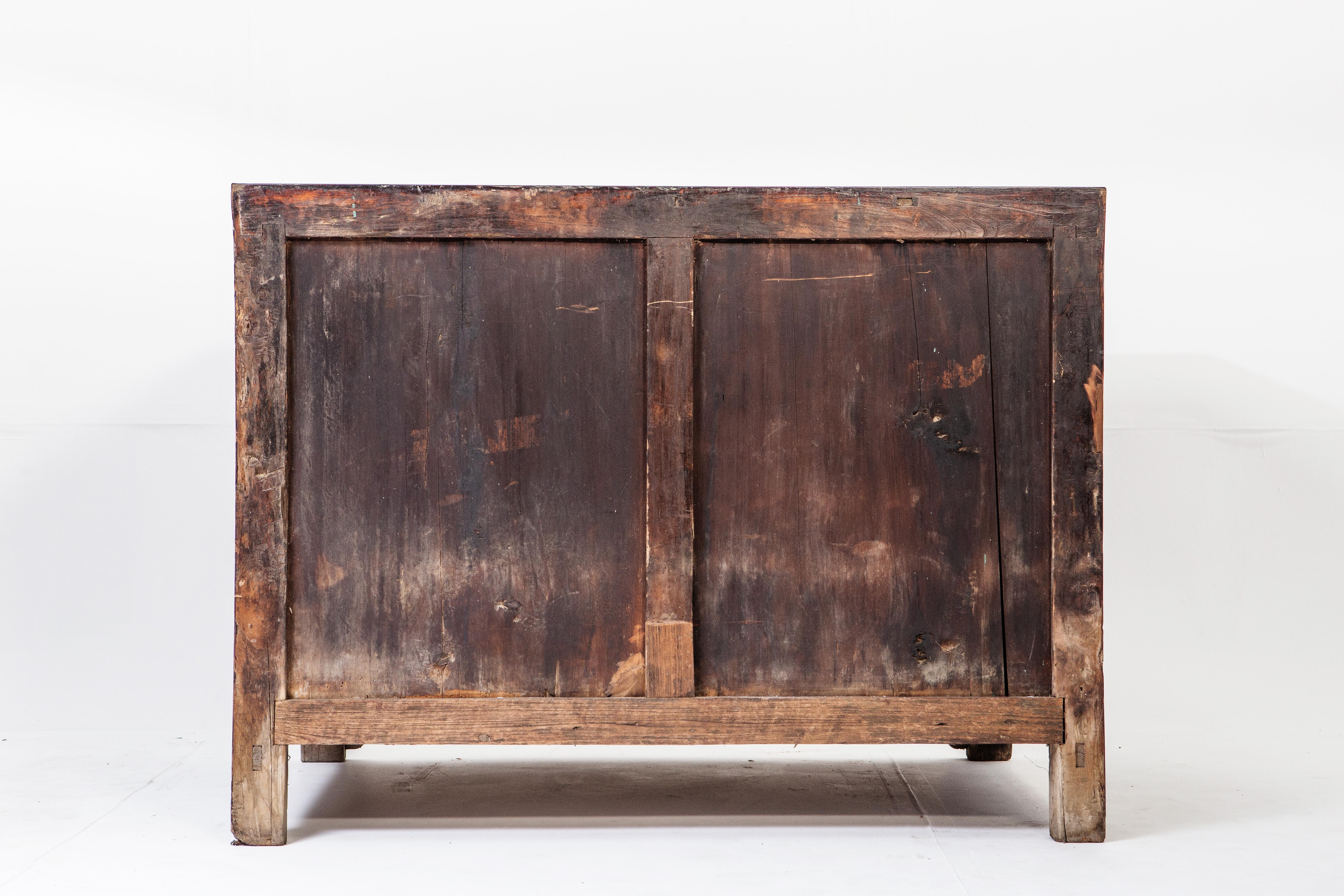This handsome storage chest is from Tianjin, China and made from elmwood and dates to the mid-1900s (during the time of Mao Zedong). The piece features three drawers, Dual opening doors, and a beautiful aged patina. Due to long use, the lacquer