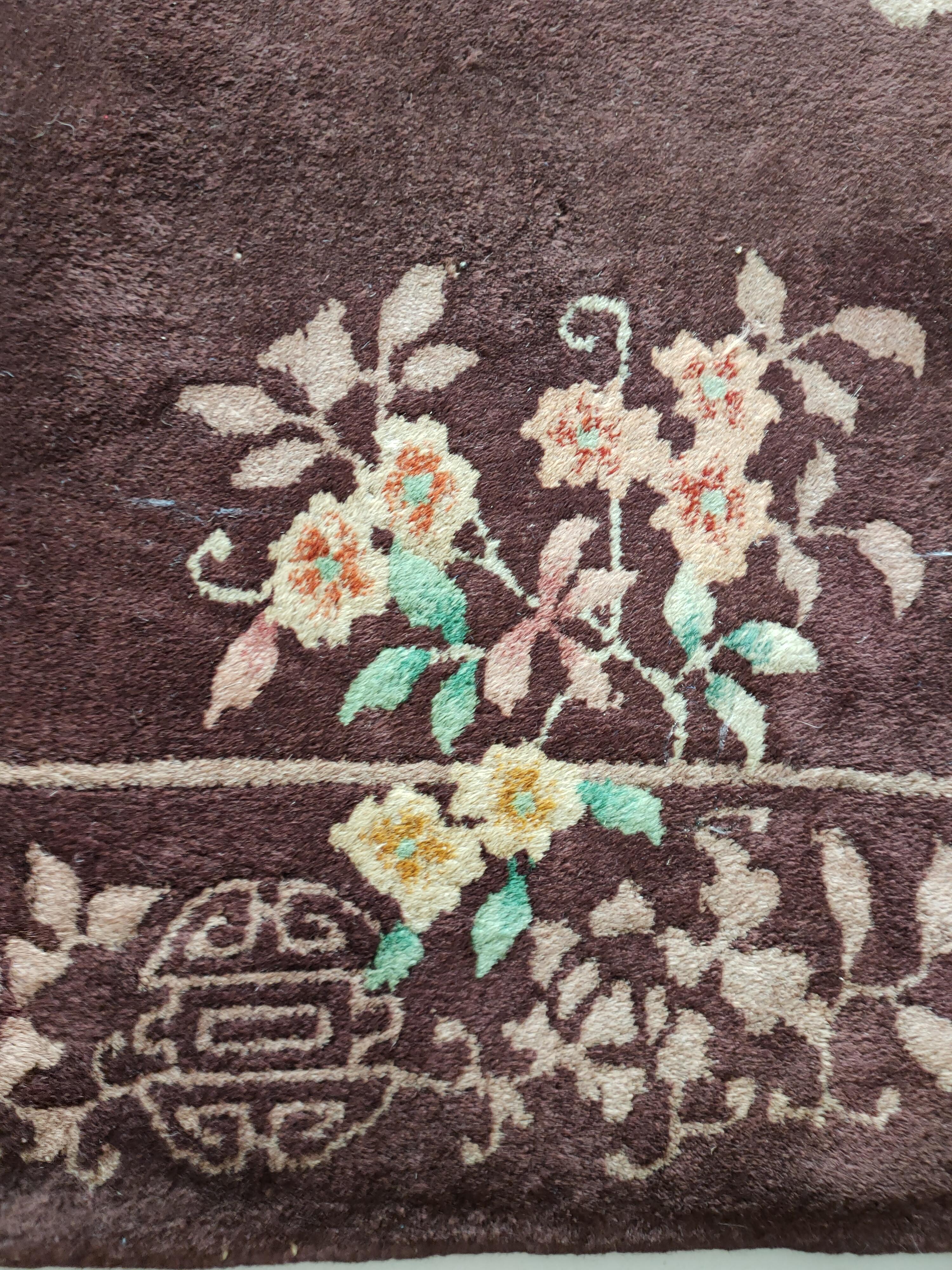 An asymmetric array of 4 flowering sprays ornaments the open scarlet field of this 1920s Art Deco rug
with a tonally matching border of four Shou (good luck) medallions and flowering arabesques featuring
peony corners. The field corners are in a