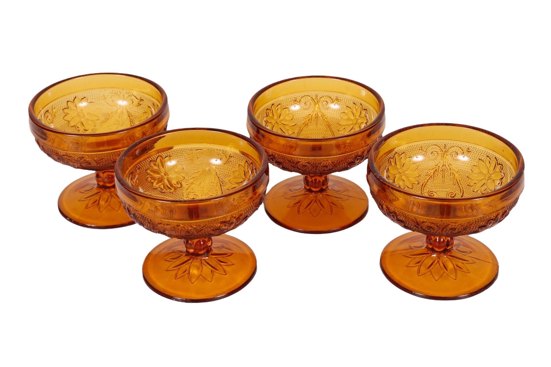 A set of four Tiara amber glass dessert bowls in the Sandwich pattern. Made by Indiana Glass Company, circa 1970. Dimensions per bowl. 