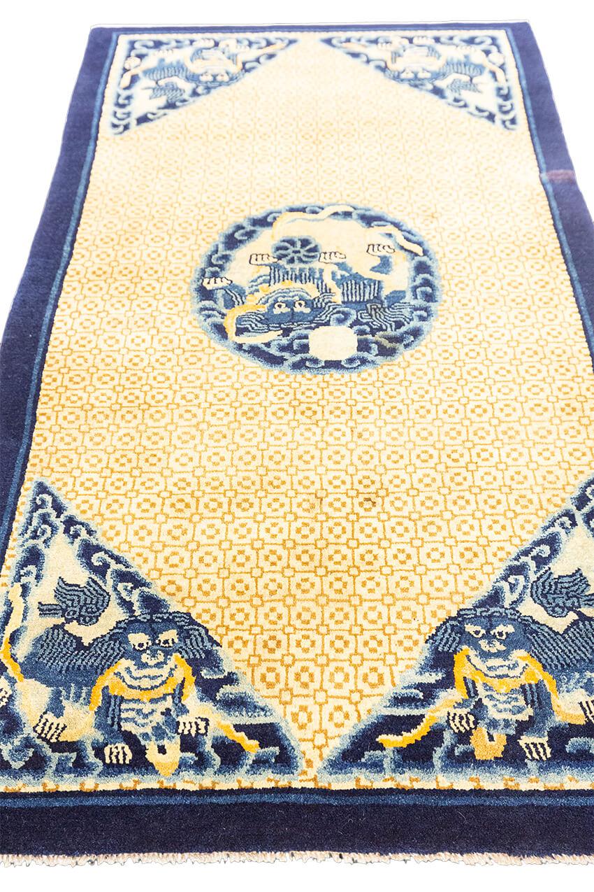 The Tibet Antique Foo Dog rug features a captivating blend of beige and blue colors in its field. This antique piece showcases the intricate artistry and cultural significance of Tibetan weaving traditions, making it a truly special and unique