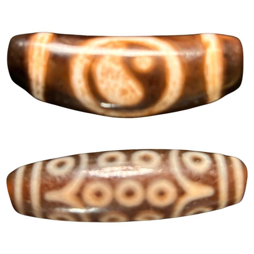A unique pair (2), valuable and powerful Protection Amulet Dzi from Tibet

A scarce Tibetan or Central Asian single eye 
