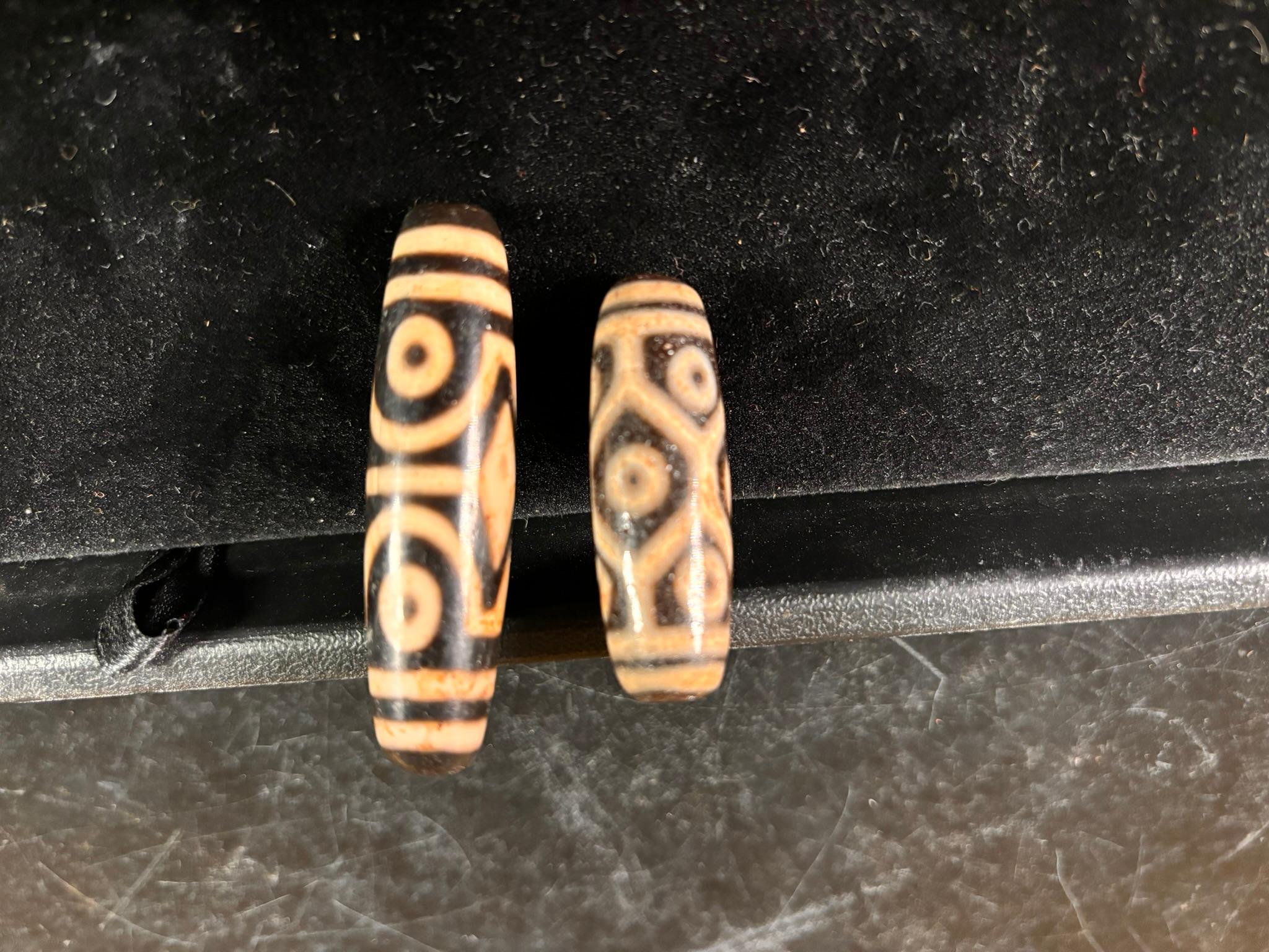 A unique pair (2), valuable and powerful Protection Amulet Dzi from Tibet

An  old Tibetan or Central Asian nine and four eye agates Dzi Beads dating to the early 20th century. These beads would make handsome spiritual talismans . 

The largest Dzi