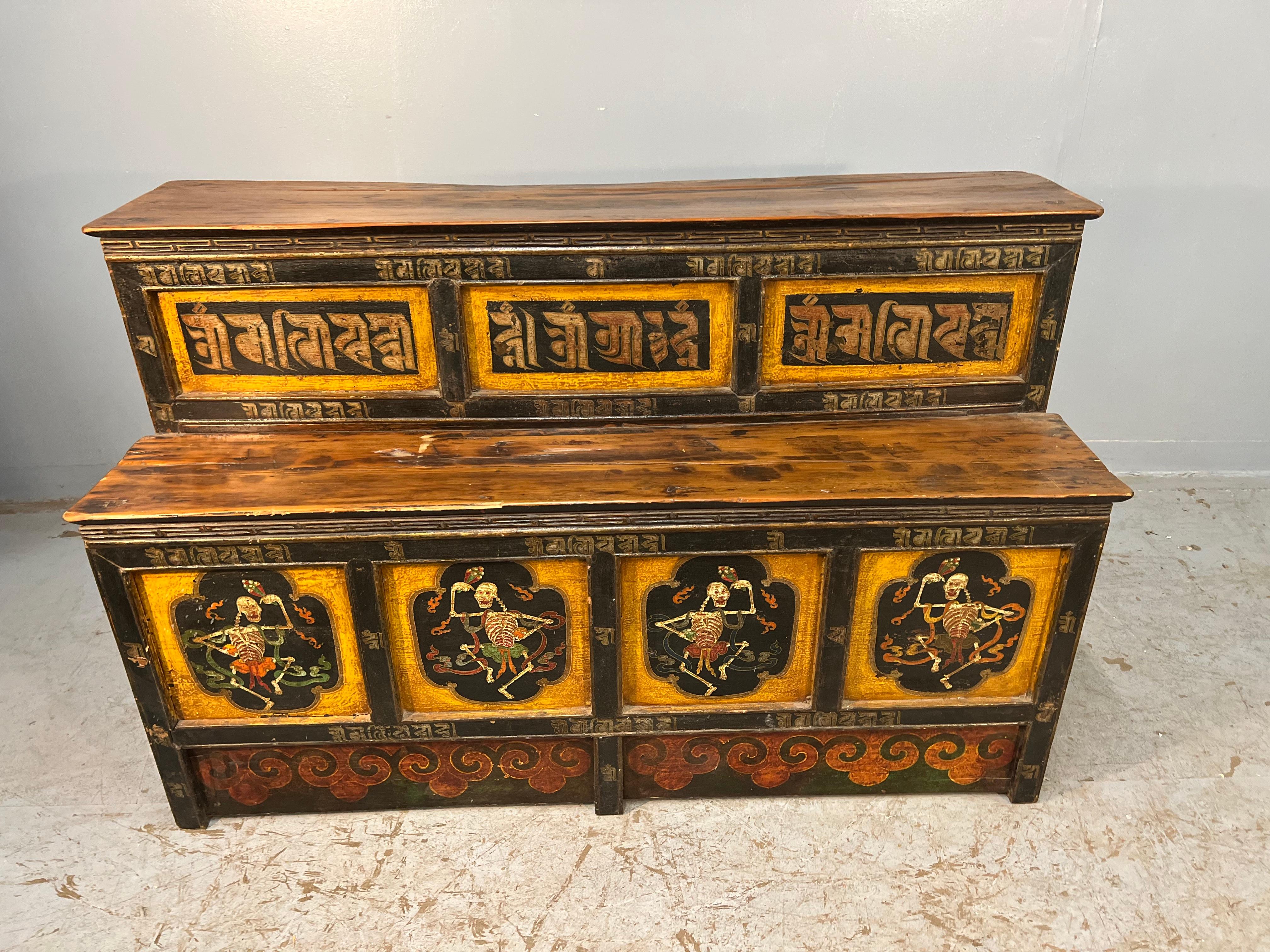A Tibetan polychromed alter table with painted skeletons. This highly decorative two tier table is painted in black, and yellow with red and green accents. 
It would make a great serving piece, hall piece, accent piece or an alter table. 
It dates