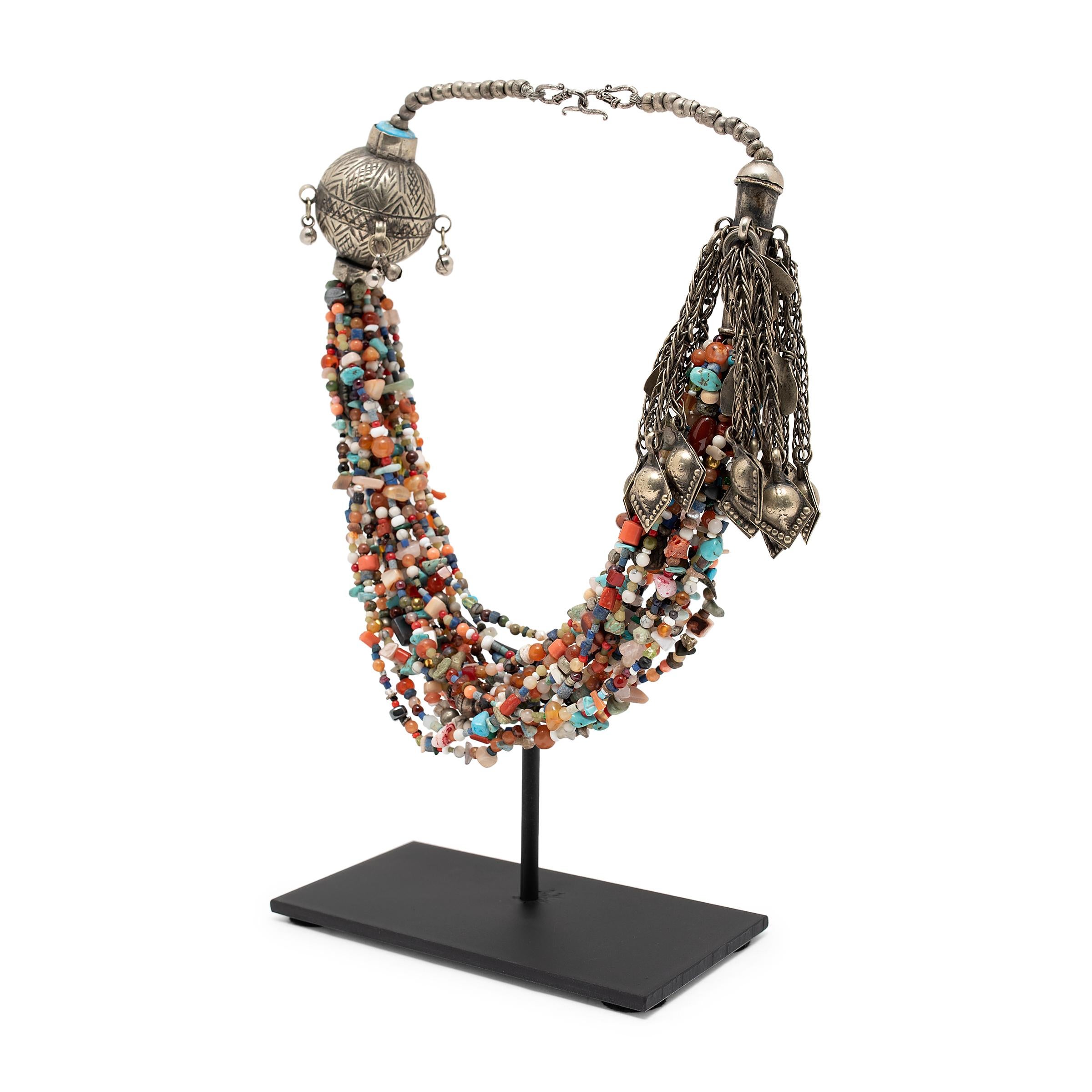 This fantastic antique Tibetan necklace is beautifully crafted of silver metalwork and draped beads of various shapes and sizes. The colorful beads include carnelian, turquoise, coral, glass, silver and other precious stones. The many strands of
