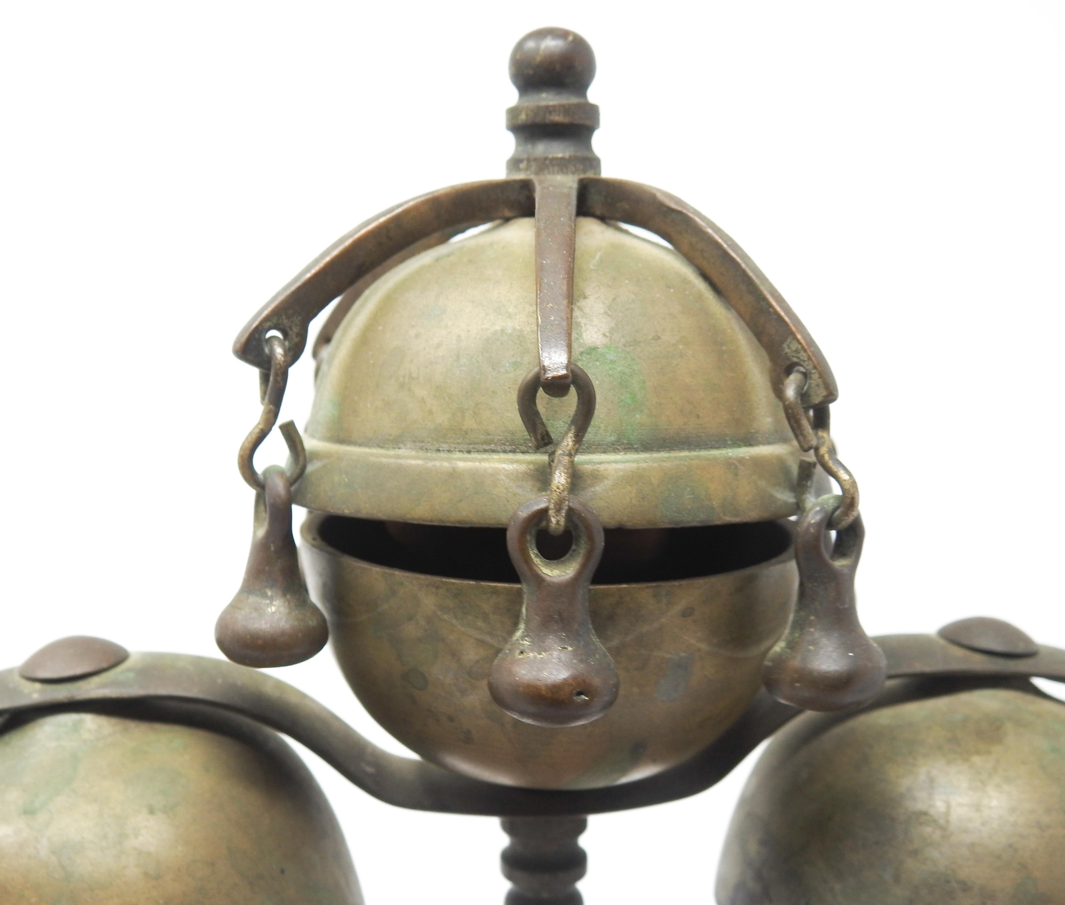 Offering these gorgeous bronze and brass meditation bells on wood stand from the late 19th Century. Starting on a handcrafted wood base that is very geometric. The curved arms holding the bells rise gracefully and meet in the middle. There are two