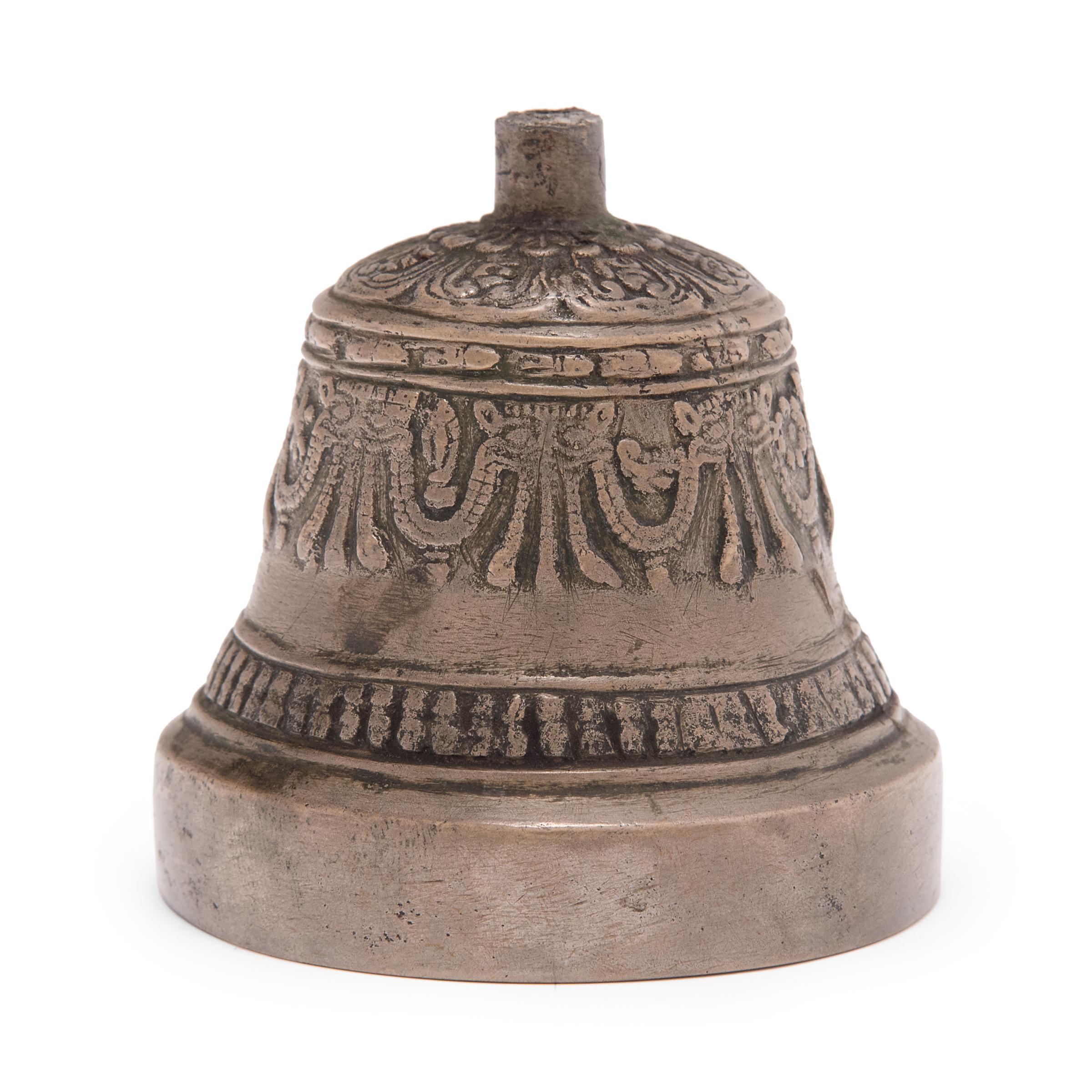 This small bronze bell is the lower half of a Tibetan ceremonial bell called a dril-bu. This example is missing its handle, which would have been shaped like a diamond scepter, or vajra, another ritual object symbolic of compassion. Used together