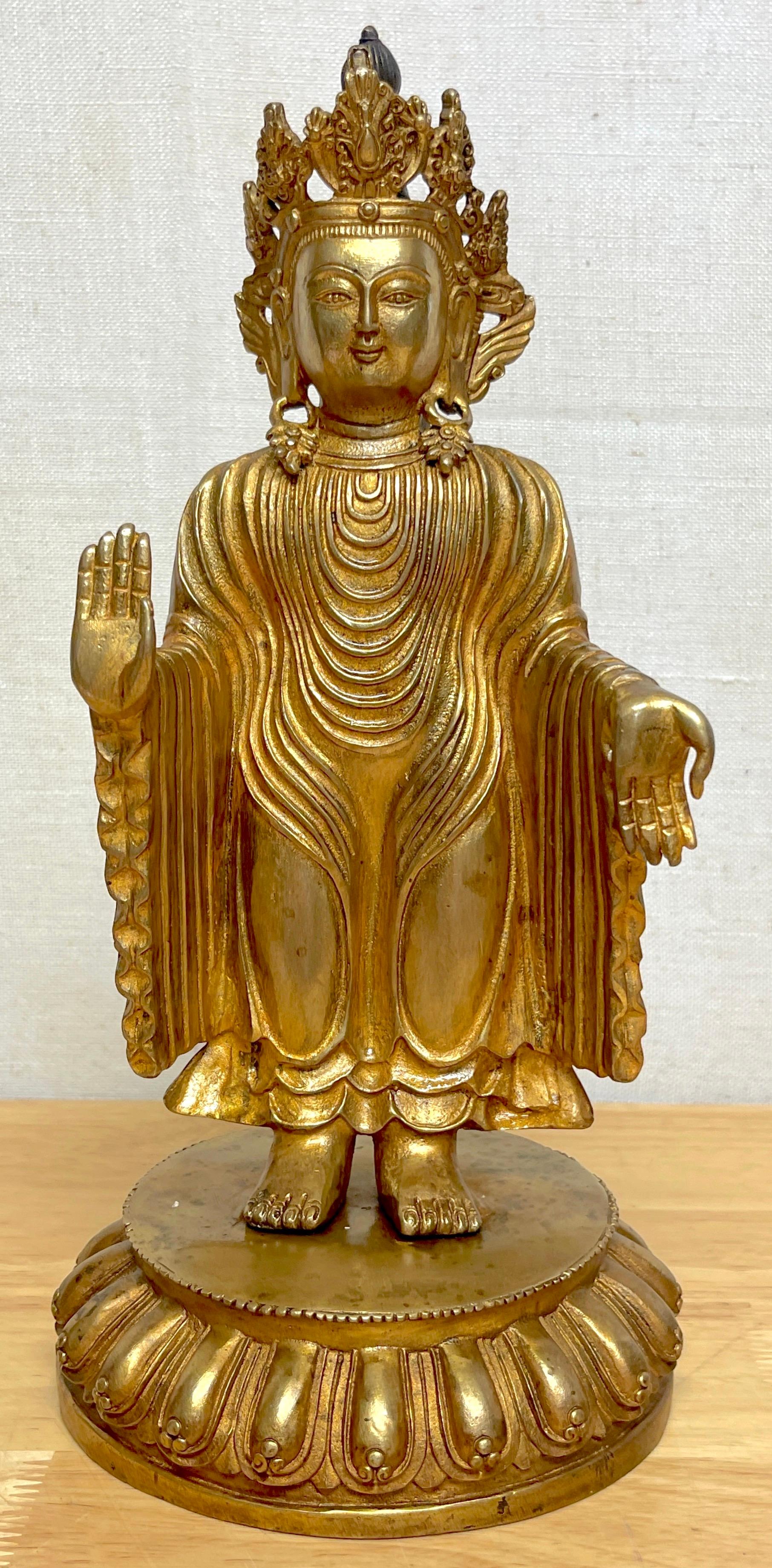 Tibetan bronze standing gilt bronze buddha offering protection 
China, 20th century 
A fine example, the Buddha standing on lotus base with the 