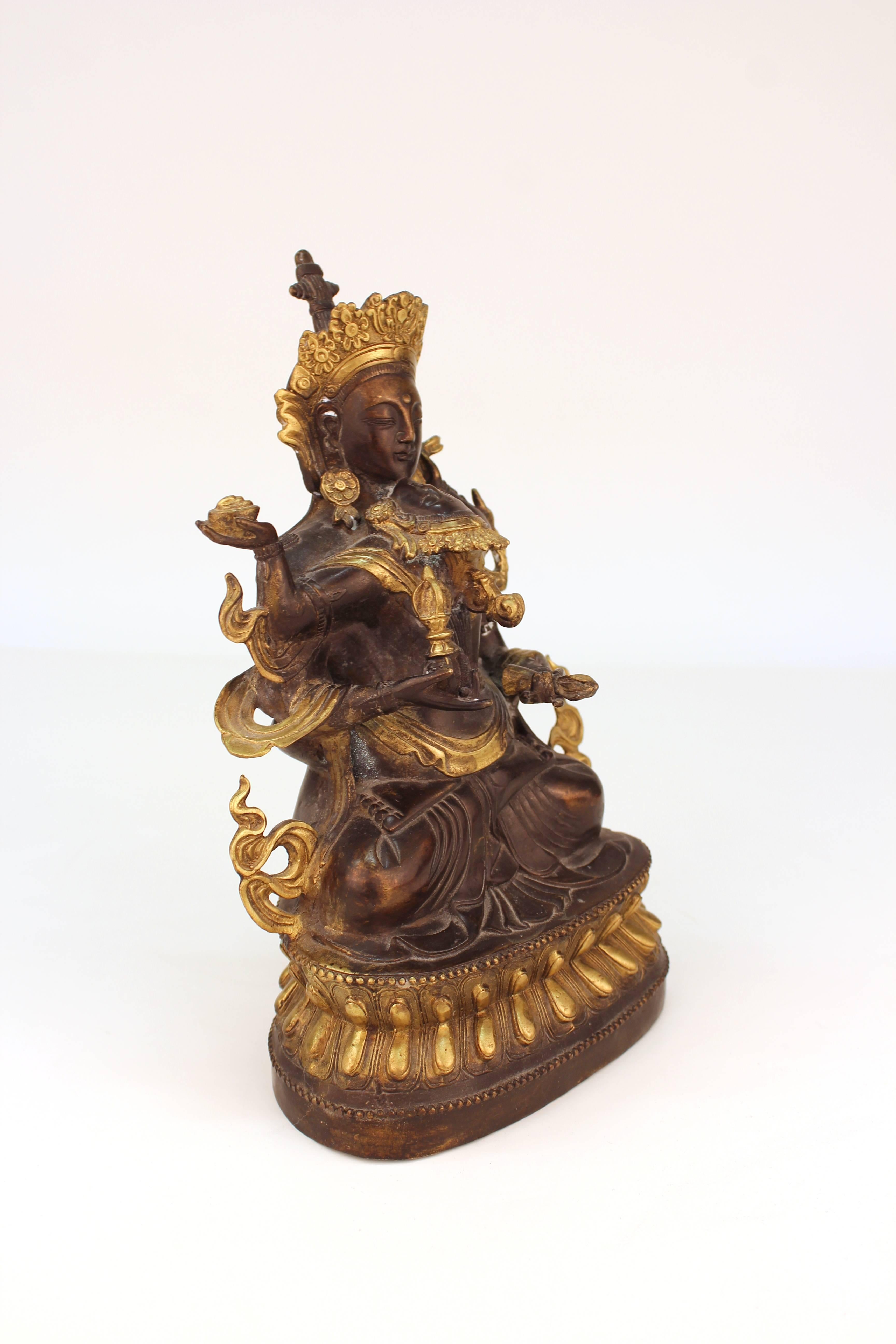 Tibetan Buddhist erotic bronze of Vajrasattva and his consort, seated on a throne, in yab yum. The cast has gilt accents and is in good vintage condition.