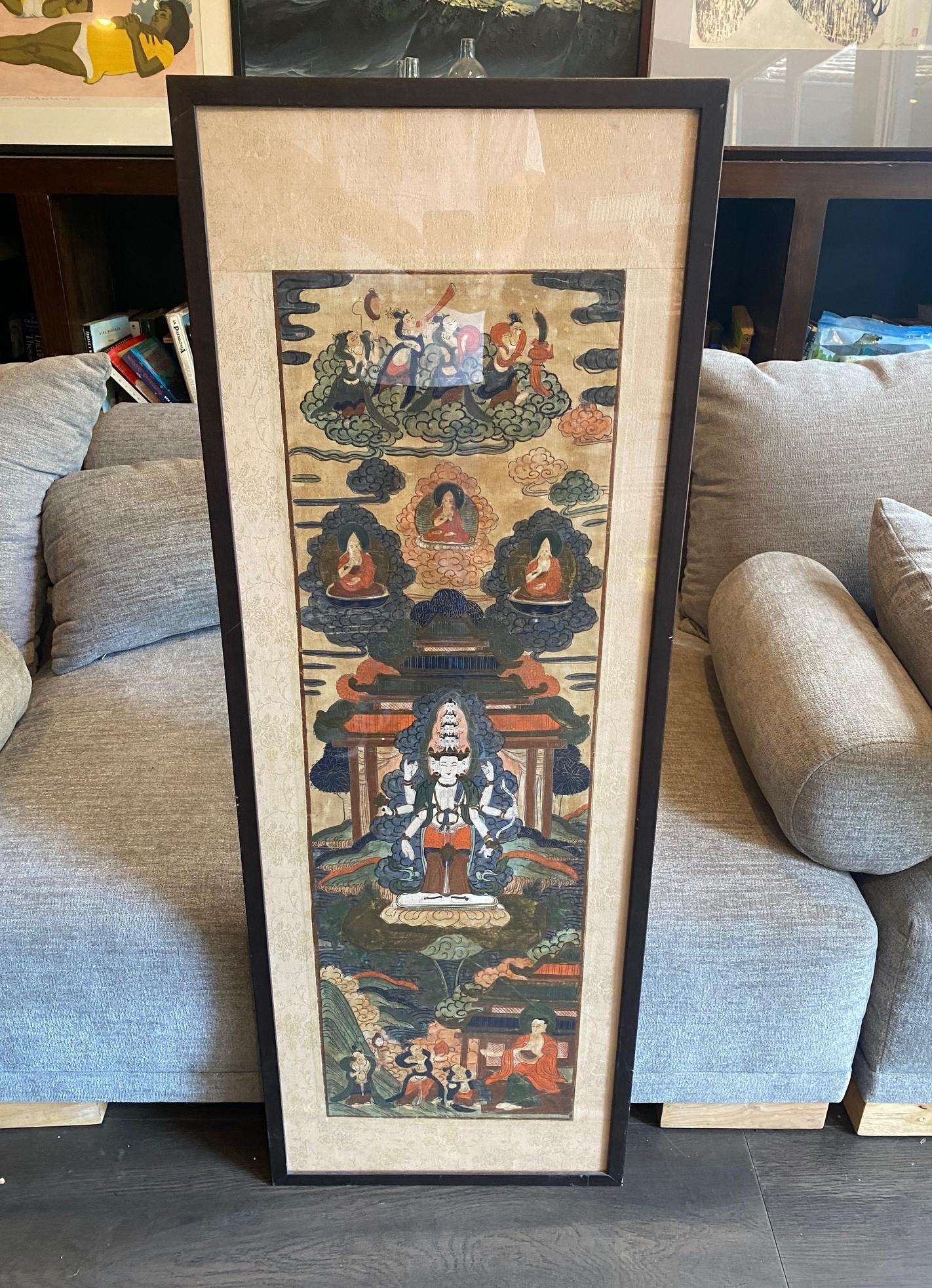 A beautiful,  vibrantly colored, intricately designed elongated Tibetan Thangka  painting featuring a multi-armed female goddess or deity (likely Avalokiteshvara, Bodhisattva of Compassion), Buddhist monks, and various ethereal figures.  .  

The
